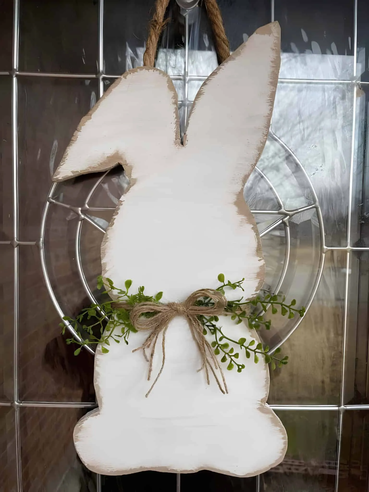 复活节门饰，配有粉彩鸡蛋、粉色花朵、胡萝卜和绿色网状丝带