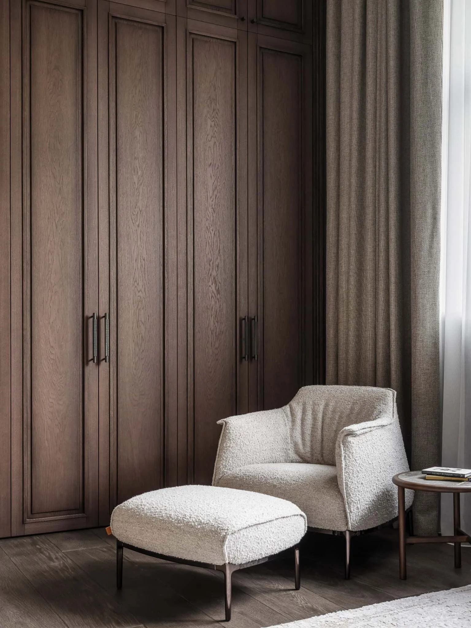 Затишний кут читання з м'яким кріслом із вовни перед вбудованою гардеробною.