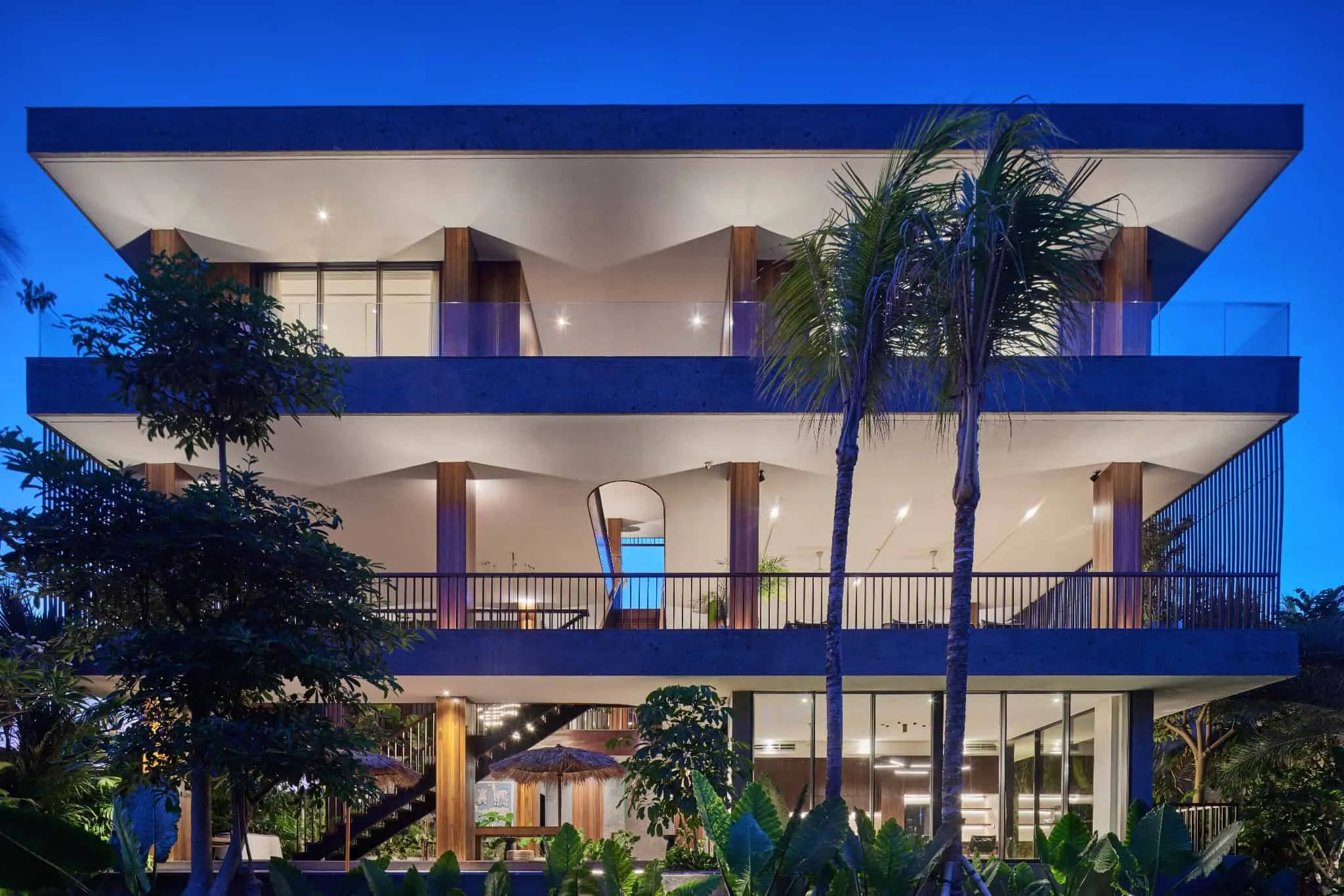 巴厘岛泳池上方的弯曲木质阳台建筑。