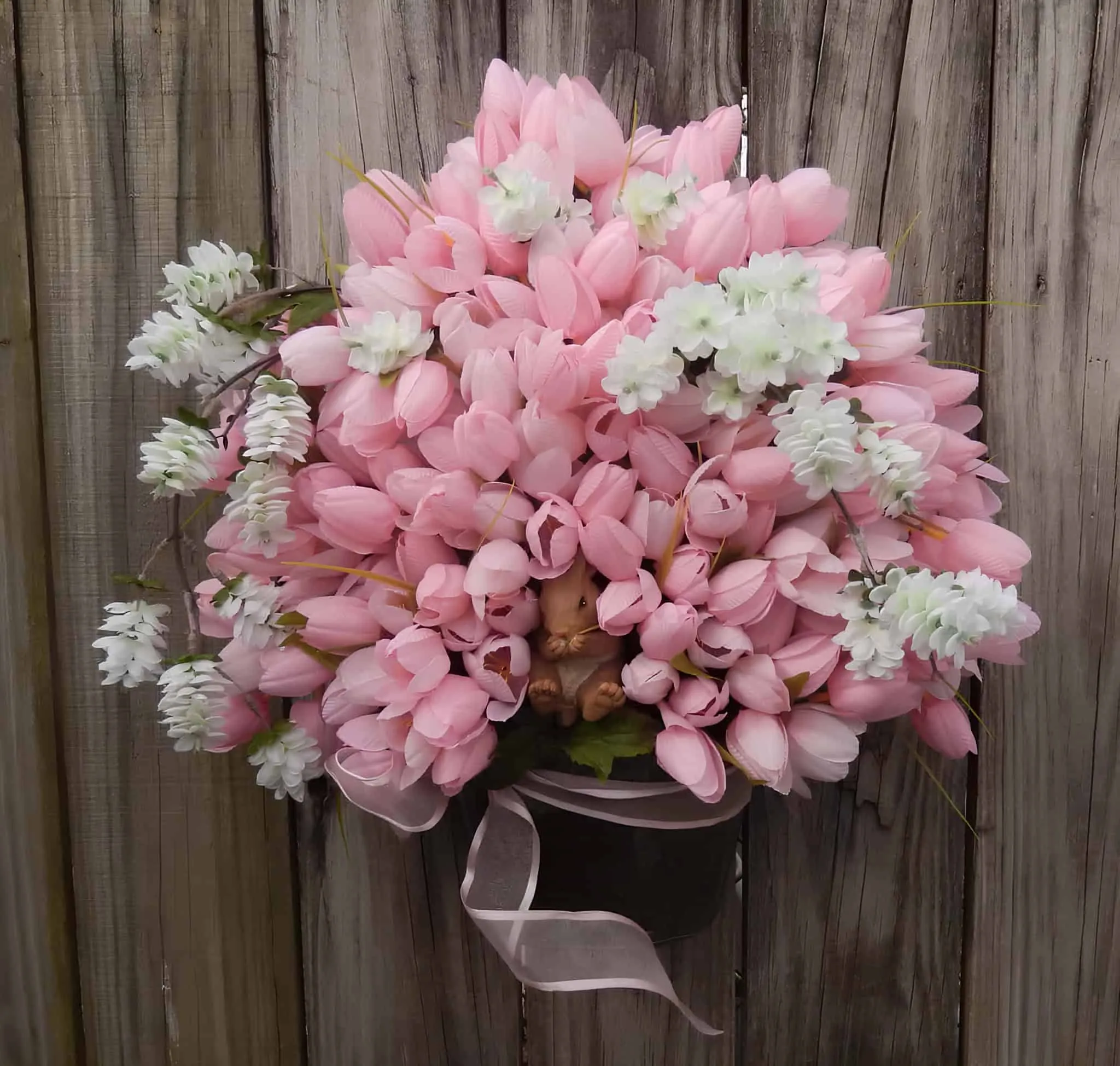 花朵复活节门饰，配有粉色和白色花朵及隐藏的兔子