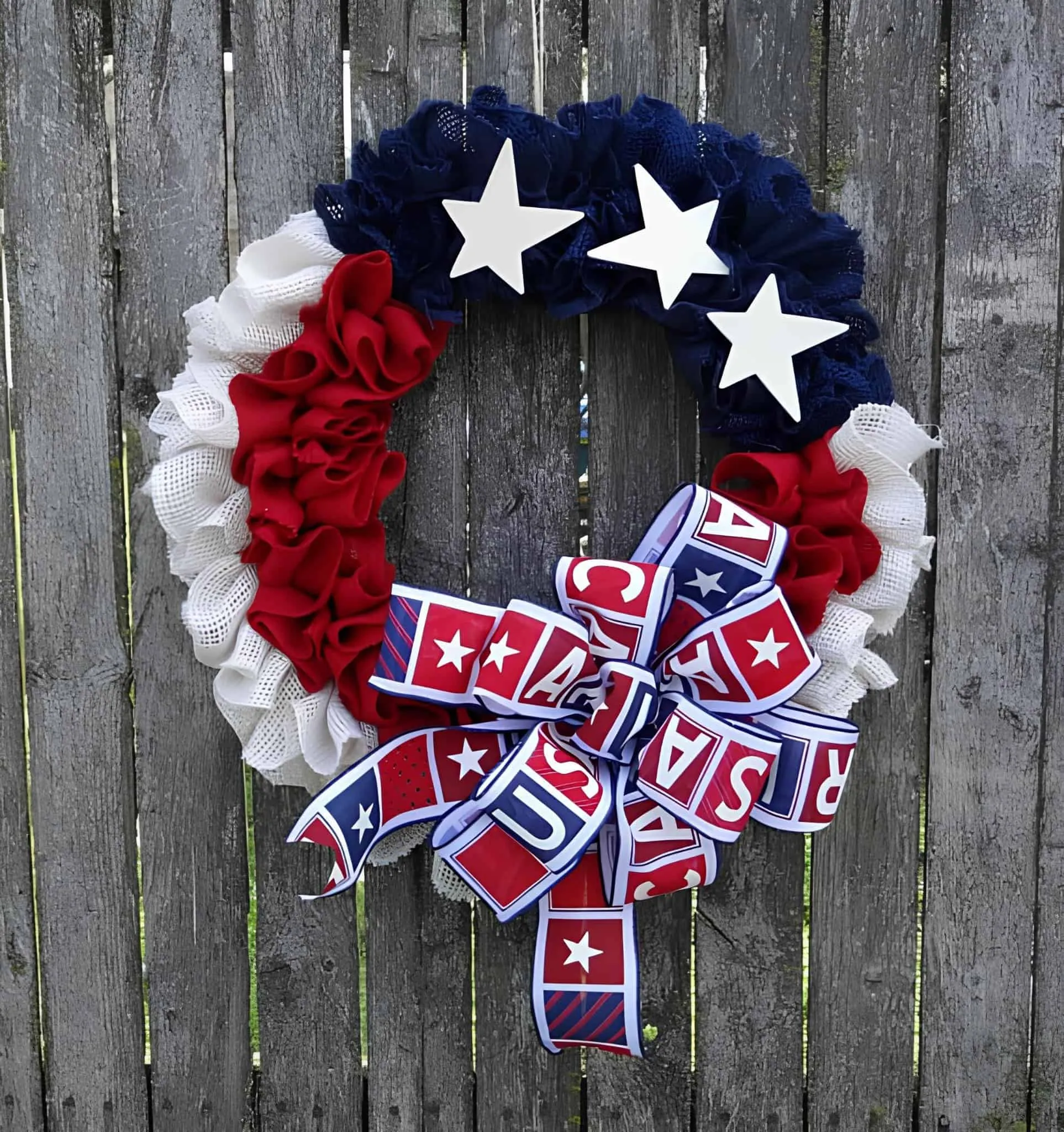 红、白、蓝三色撕裂网格花环，配有星星和爱国丝带