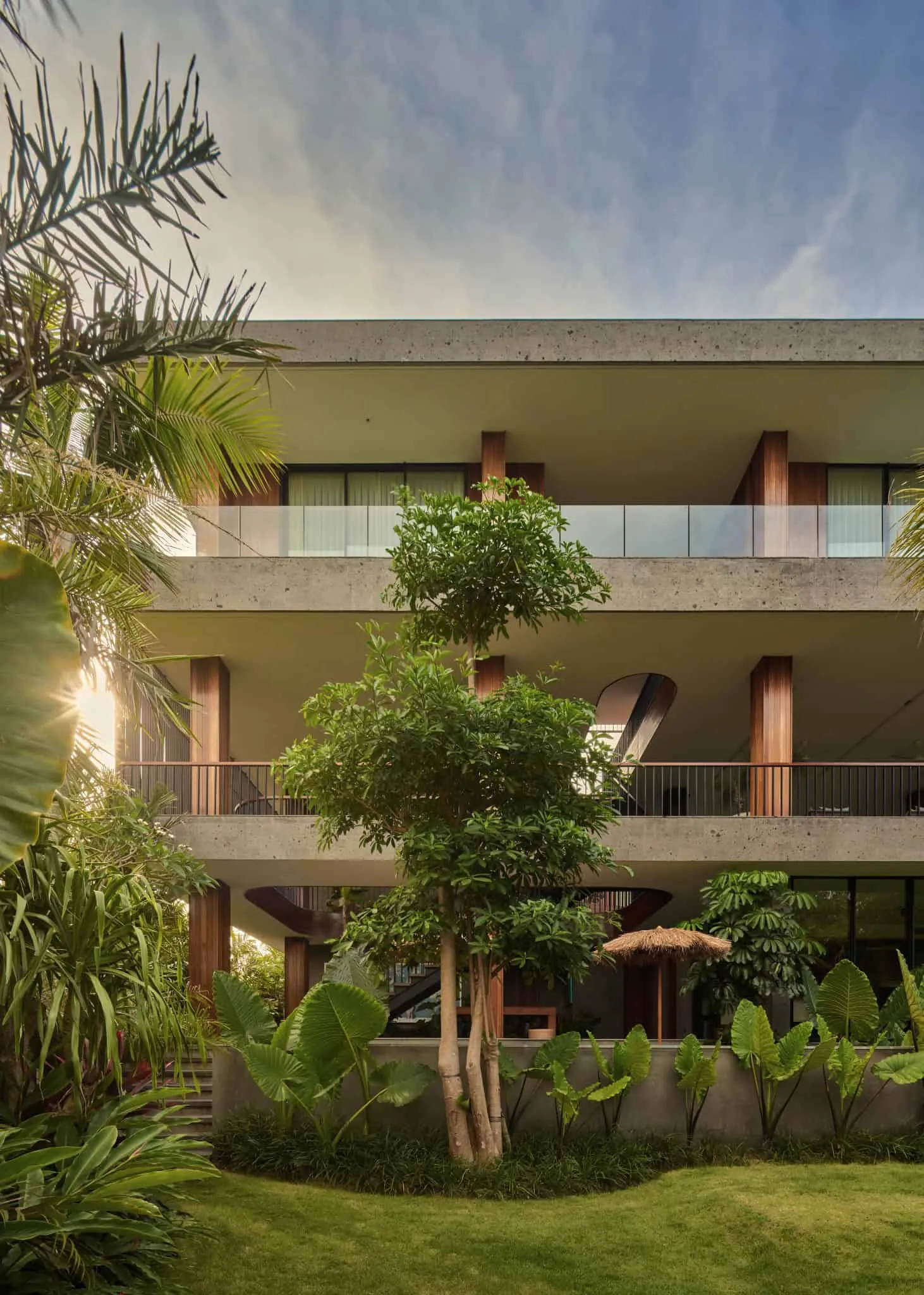 巴厘岛现代别墅，被绿色植物和石质立面环绕。