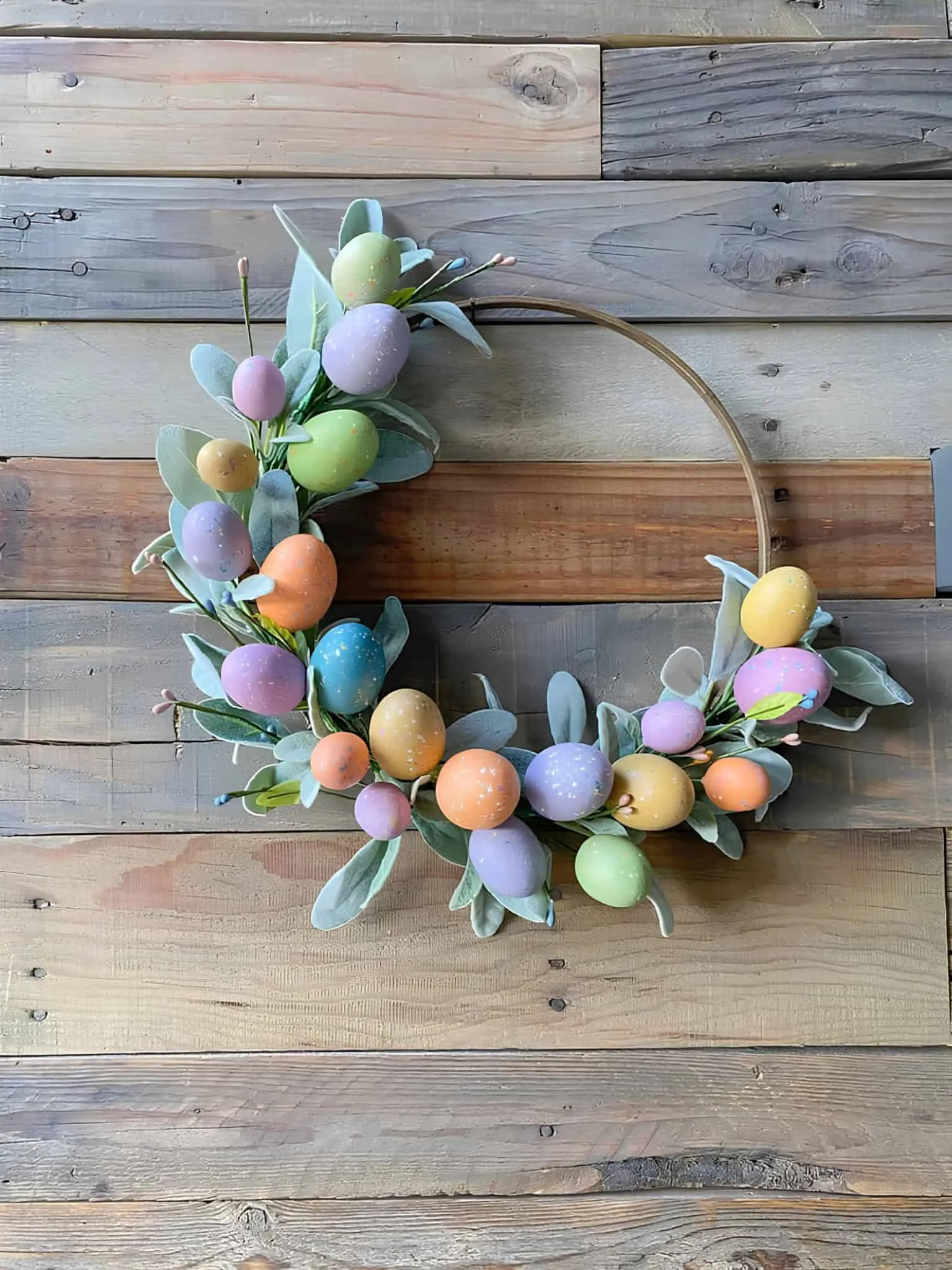 200+ 美丽的复活节门饰创意,适用于 2025 年 极简复活节门饰,配有粉彩鸡蛋和绿叶在木制框架上