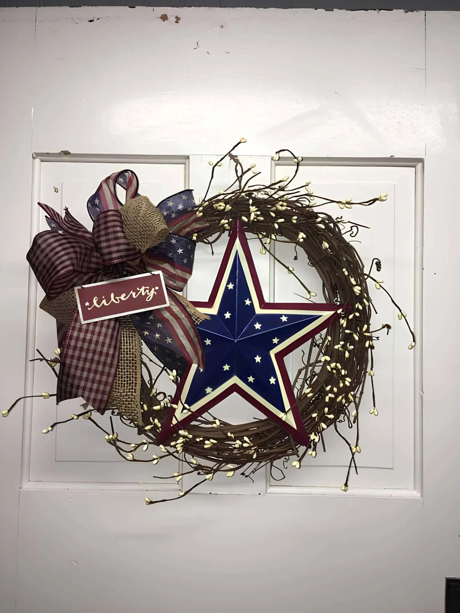 乡村葡萄藤花环，中央有大星和'自由'标语及爱国丝带