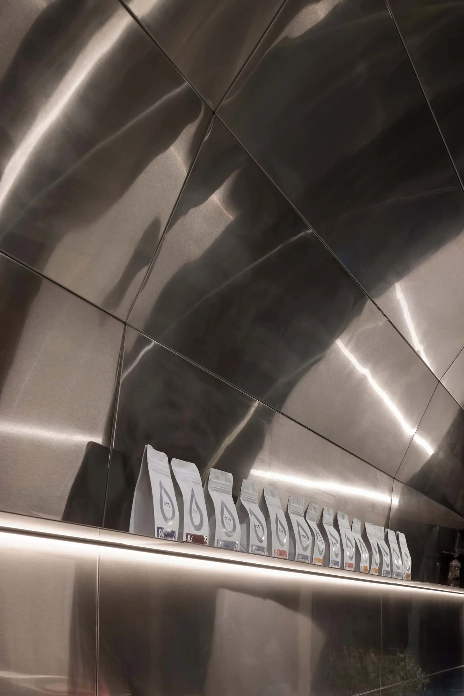 金属货架上展示的咖啡豆包，配有柔和照明