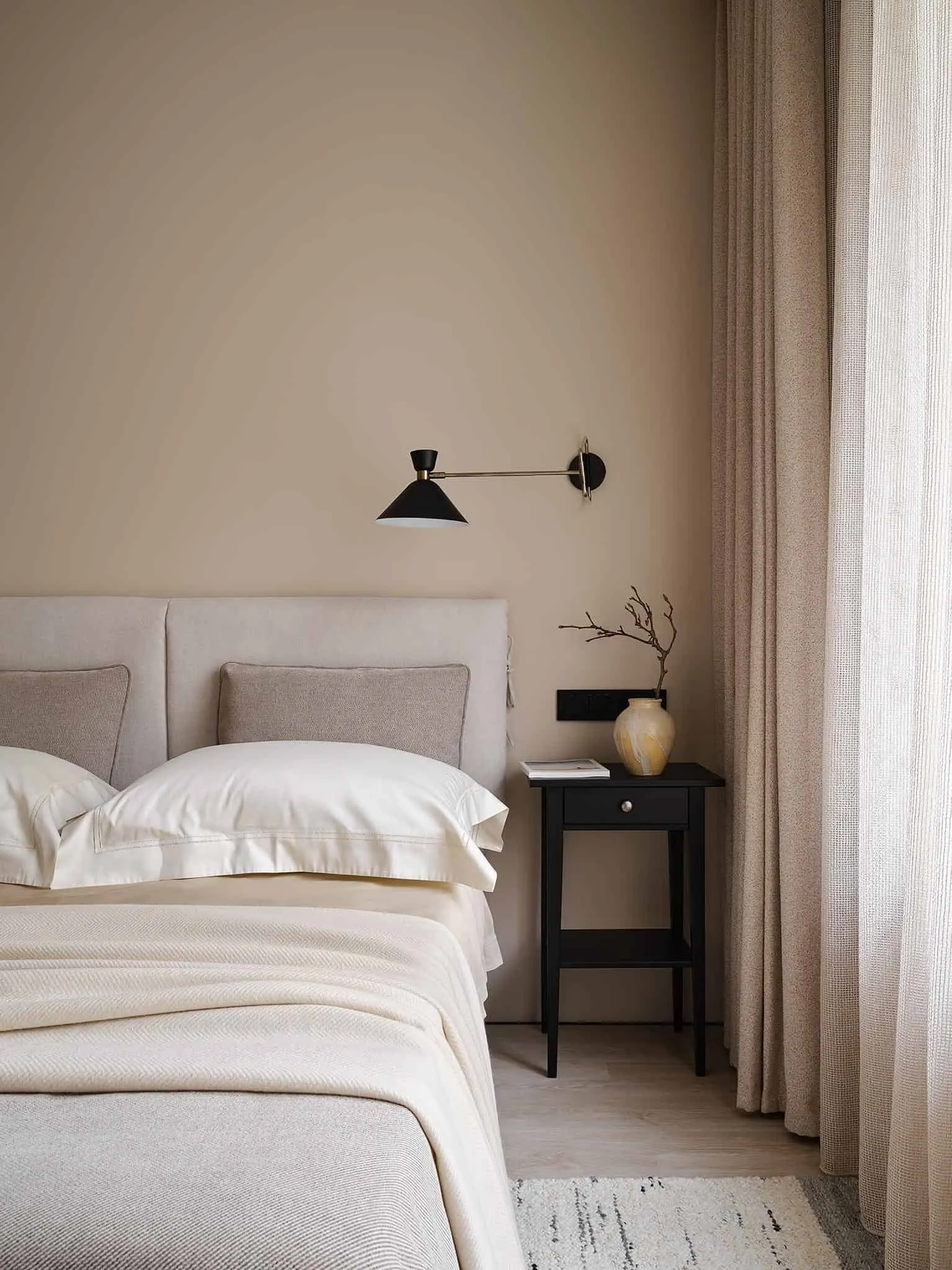 配有两黑色床头柜和柔和照明壁灯的中性卧室。