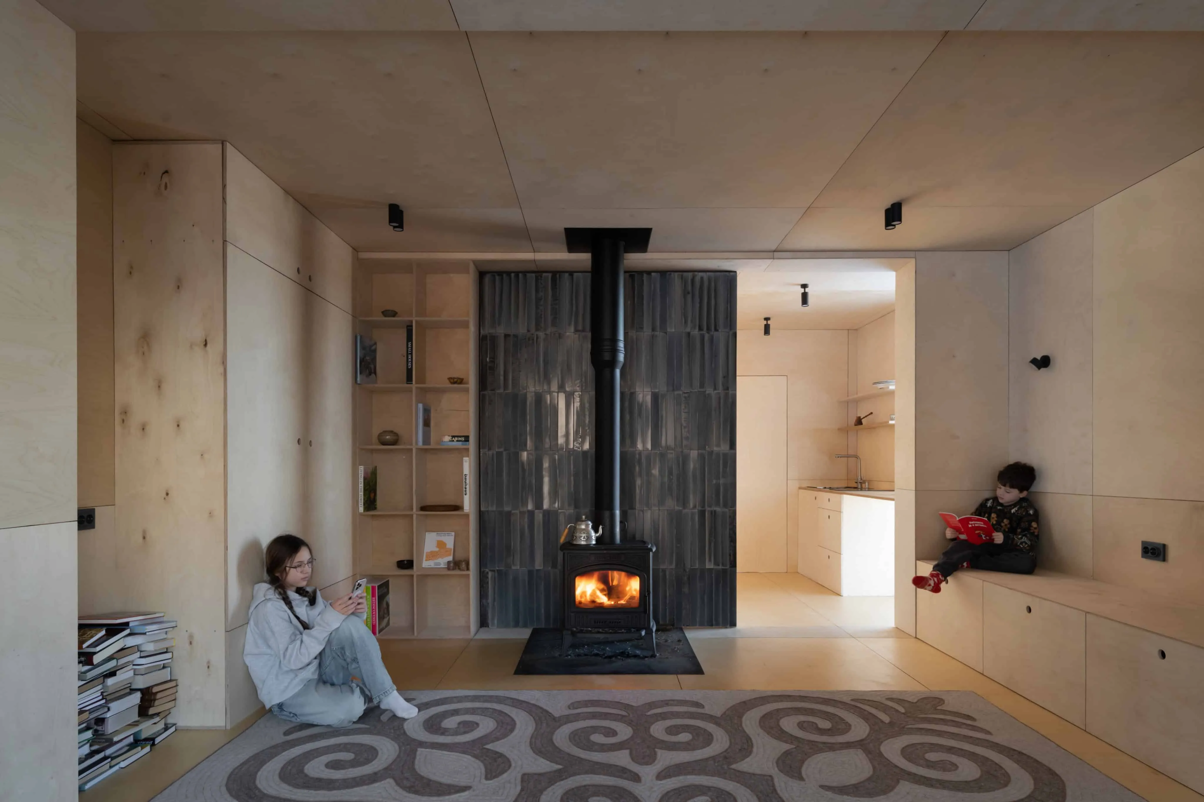 极简木制内饰，中央设有壁炉，一家人享受温馨氛围。