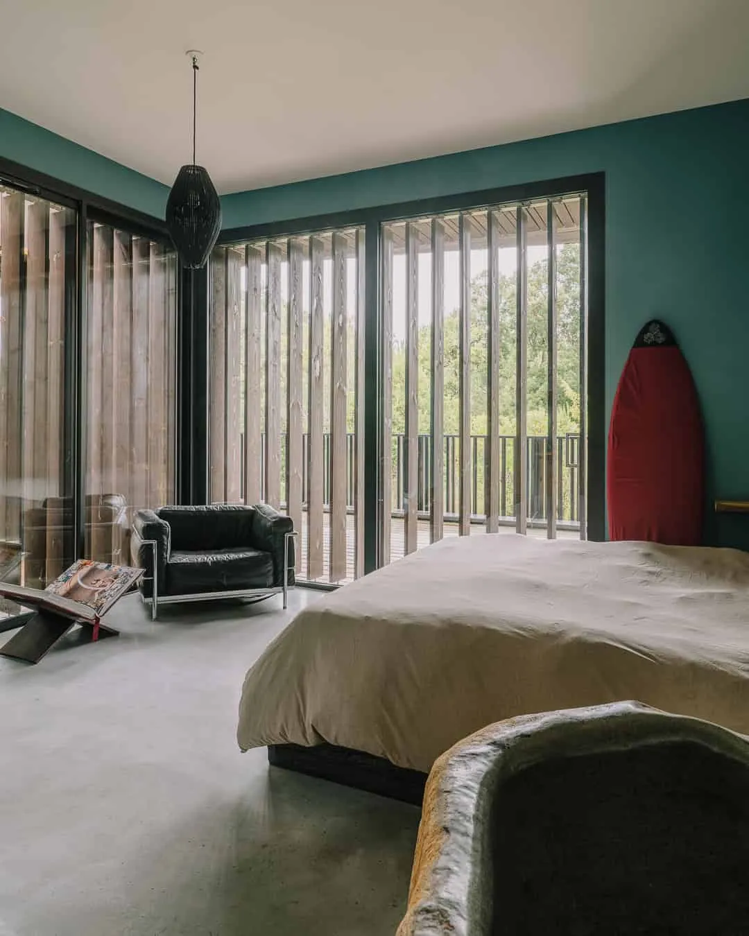 温馨的蓝色墙壁卧室，直接通往面向森林的阳台。