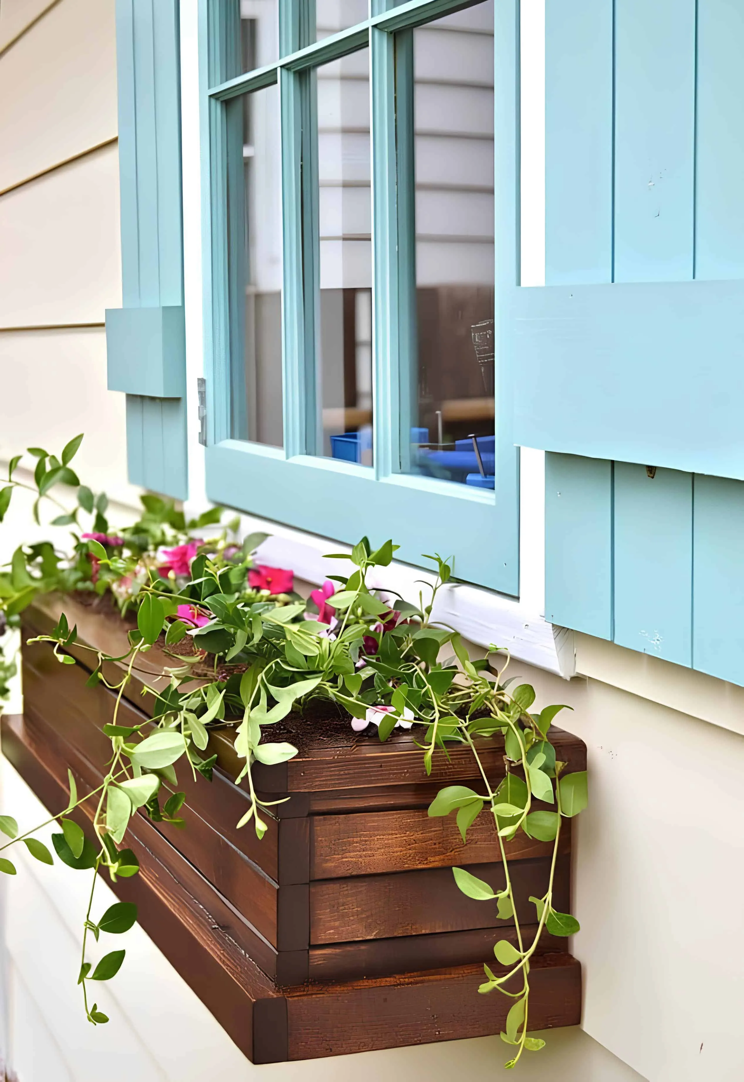 在舒适的露台上，高大的蓝色木质花盆配有茂盛的紫罗兰