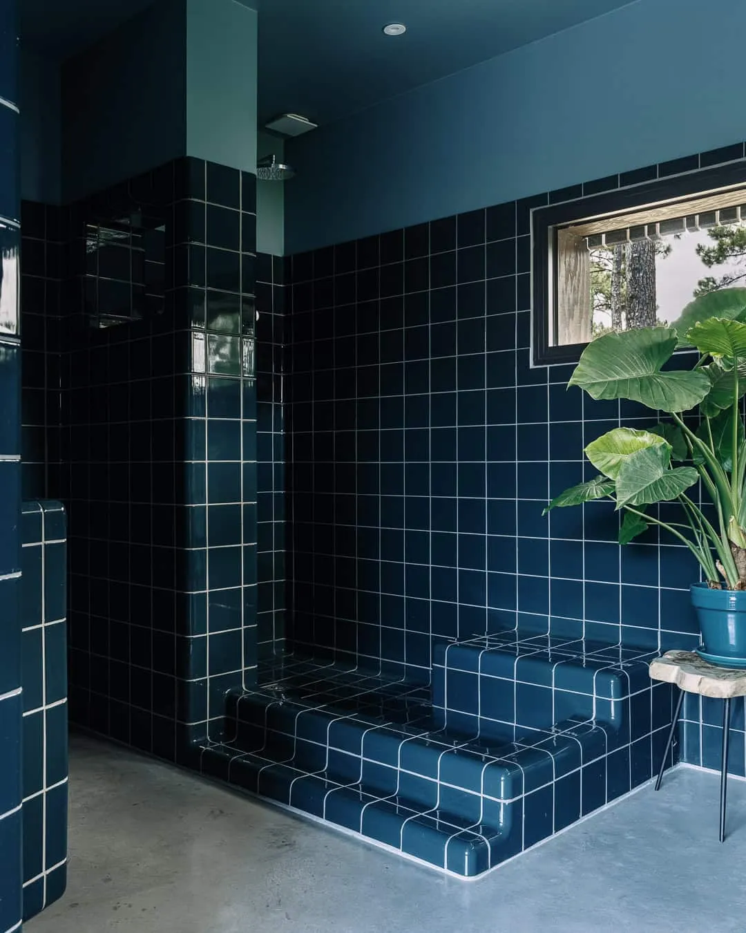 带深蓝色方形瓷砖和淋浴间的浴室。