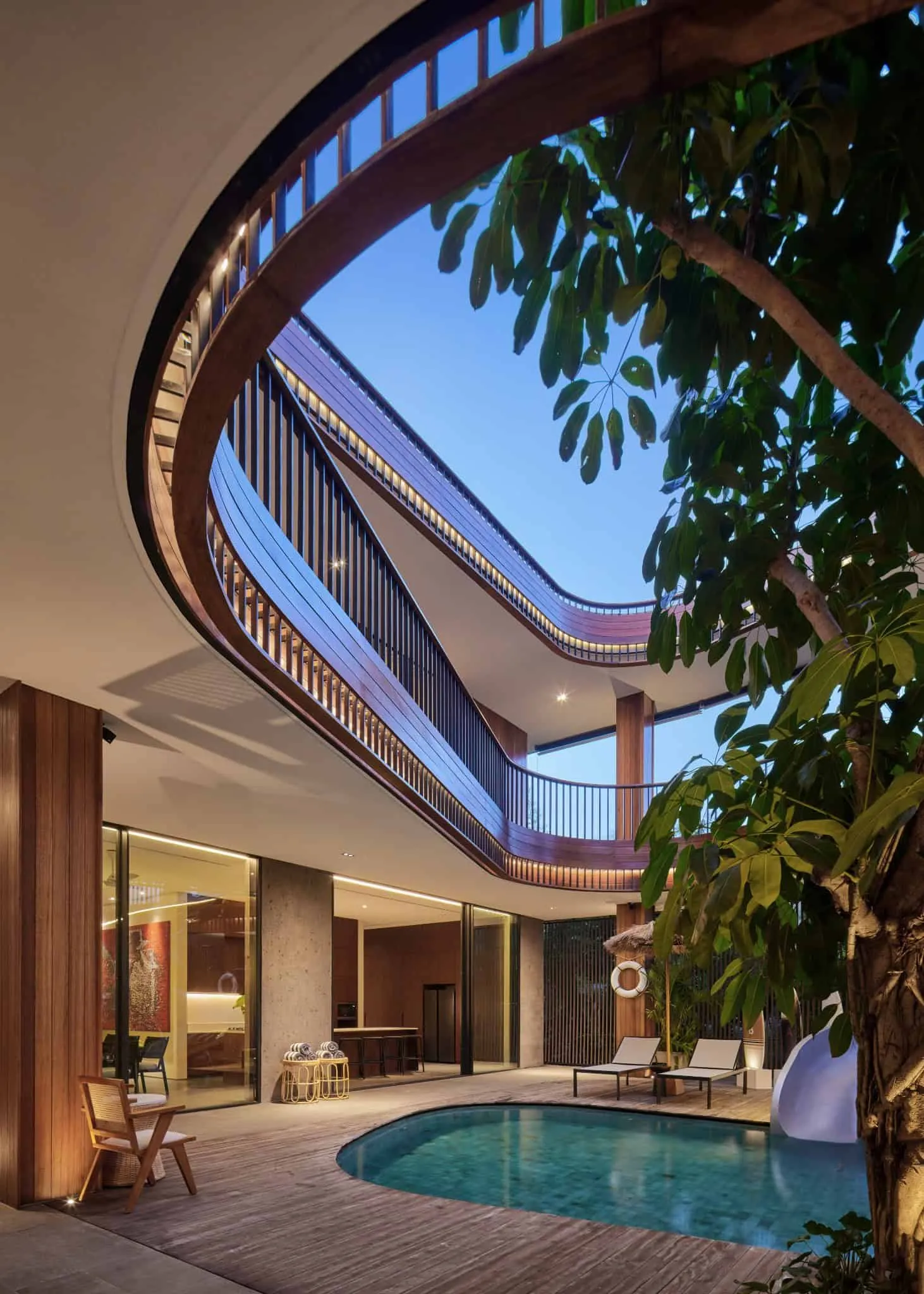 泳池上方带有木质和玻璃细节的弯曲阳台结构。