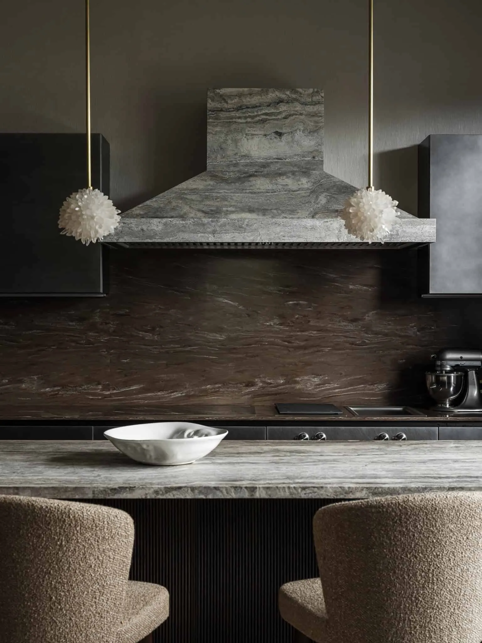 Текстурований кухонний вентилятор і столешниця з каменю з м'яким сучасним освітленням.