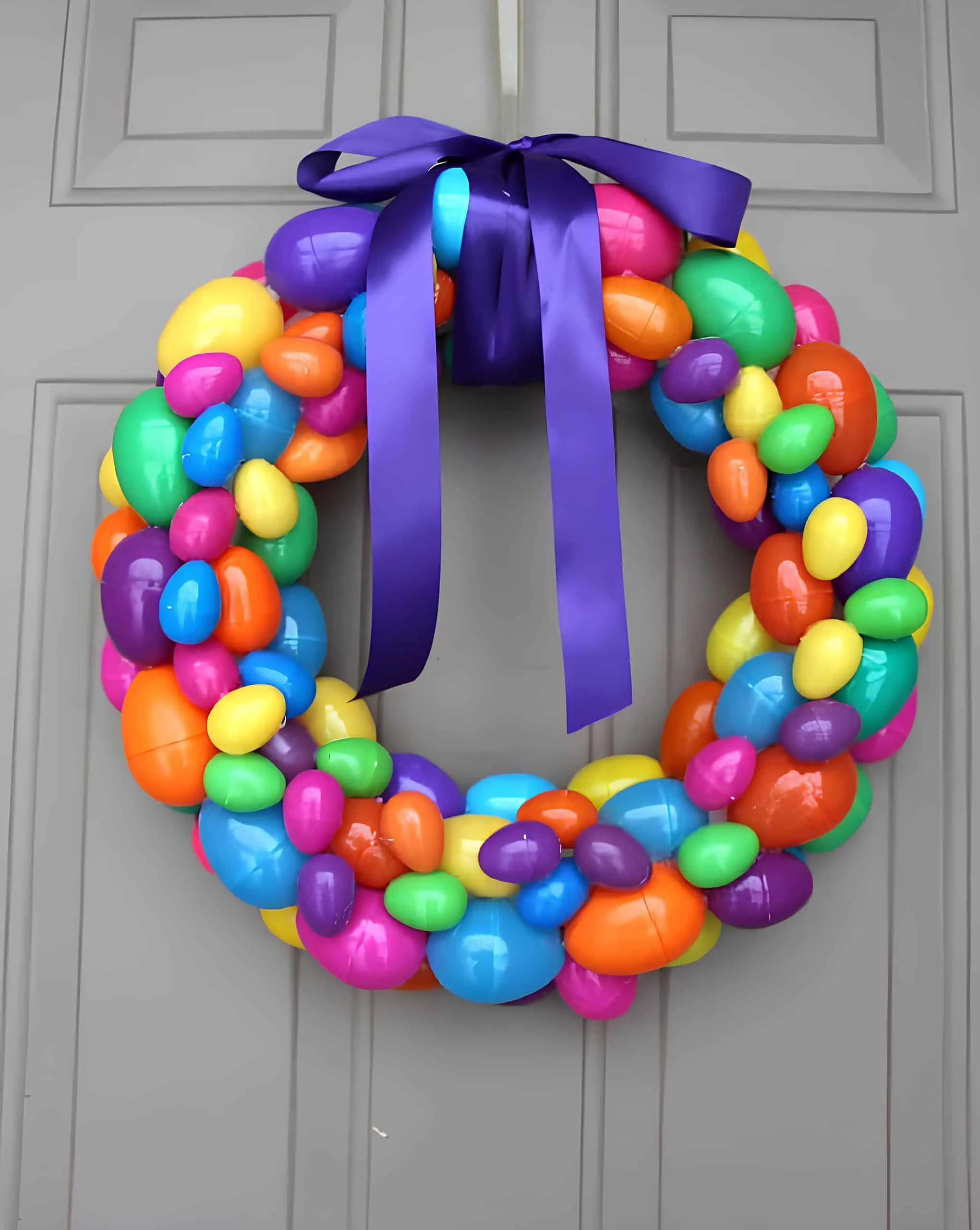 明亮的塑料鸡蛋门饰，悬挂在灰色门上。