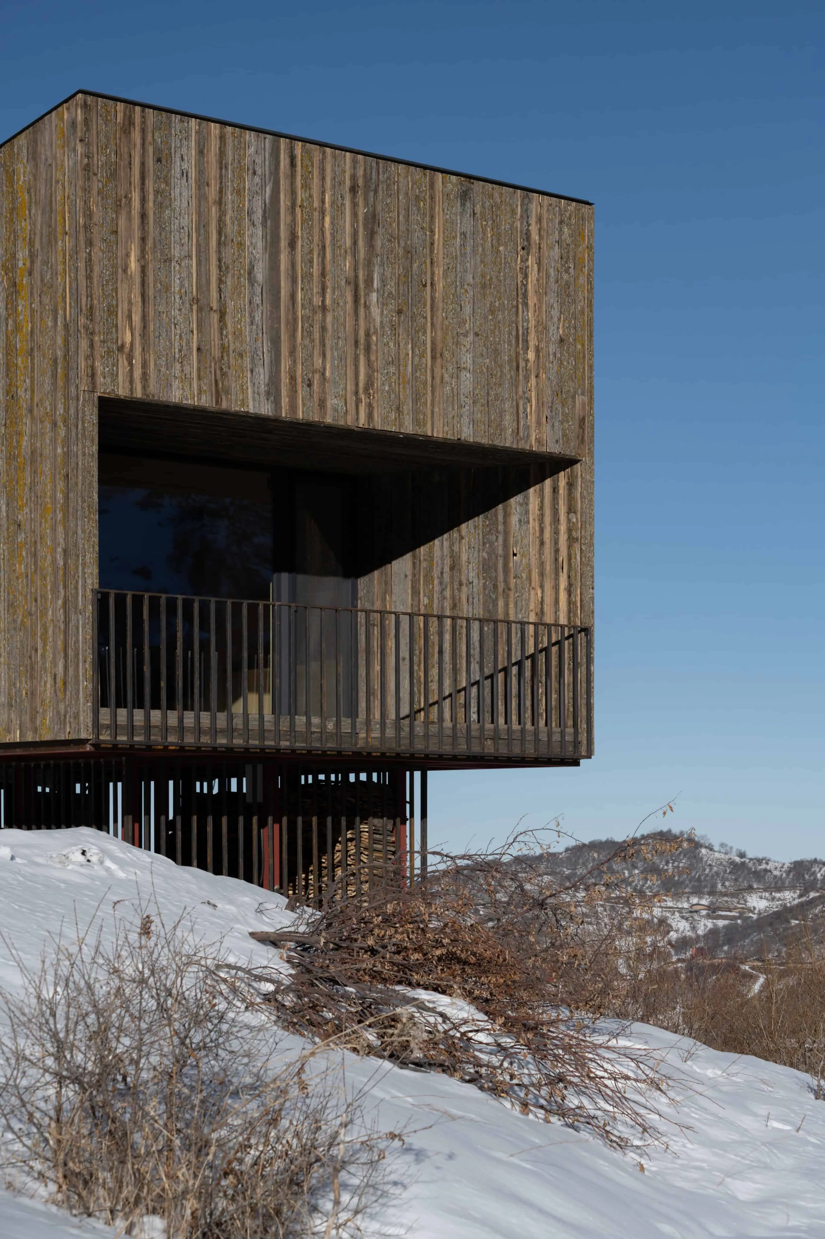 现代突出结构的小屋在雪坡上。