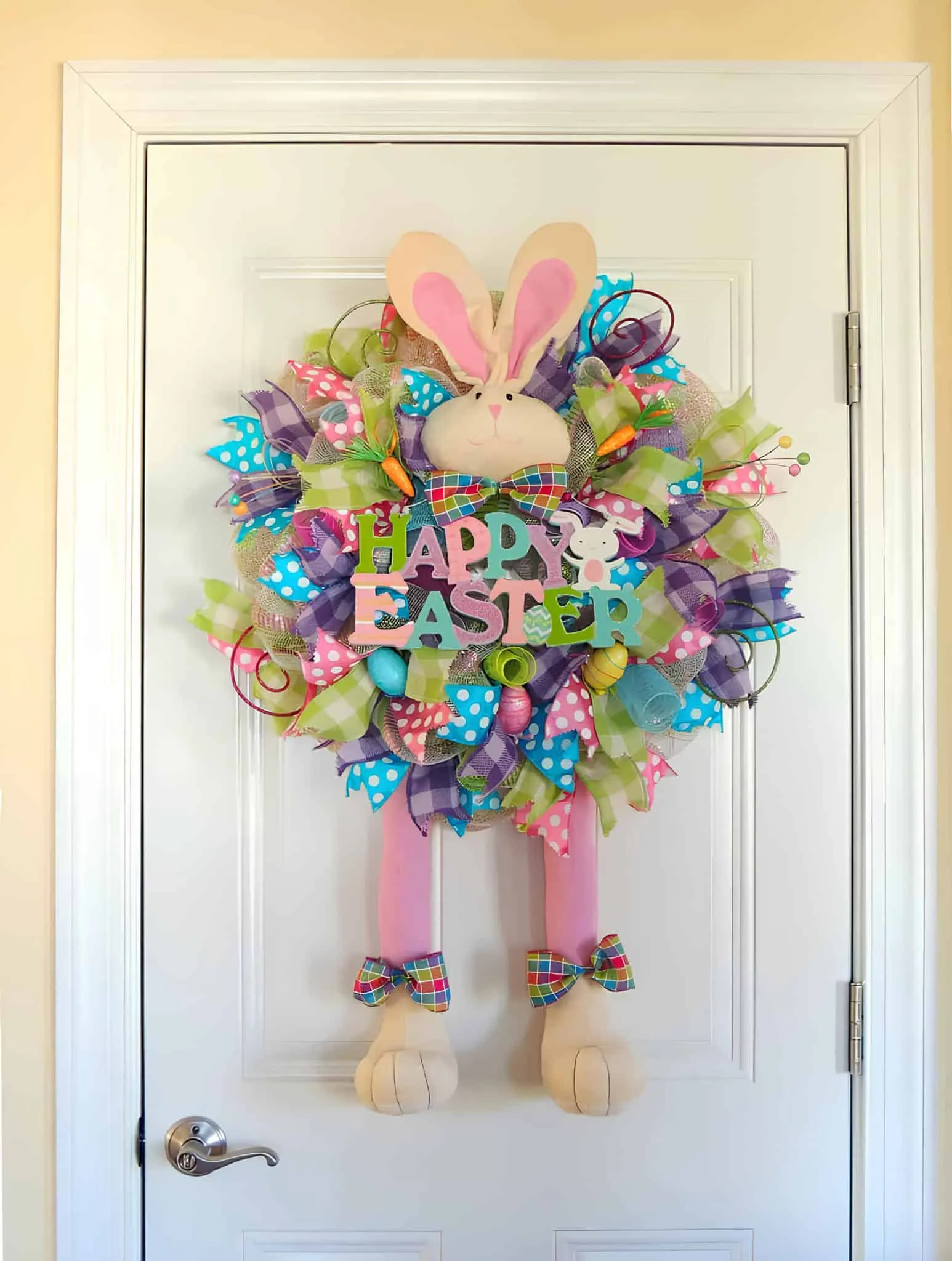 明亮的复活节门饰，配有中央兔子和彩色“复活节快乐”标志