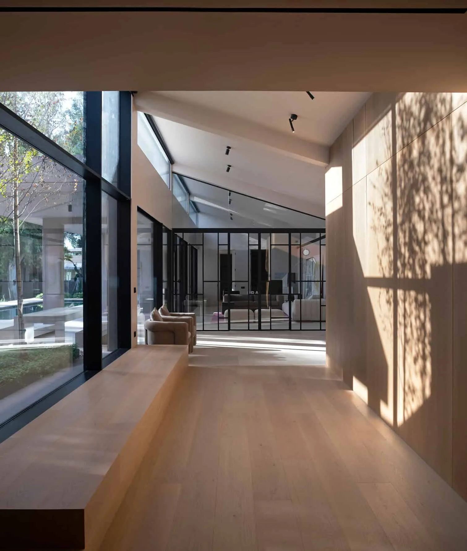 自然采光、木质地板和内置长椅的明亮走廊。