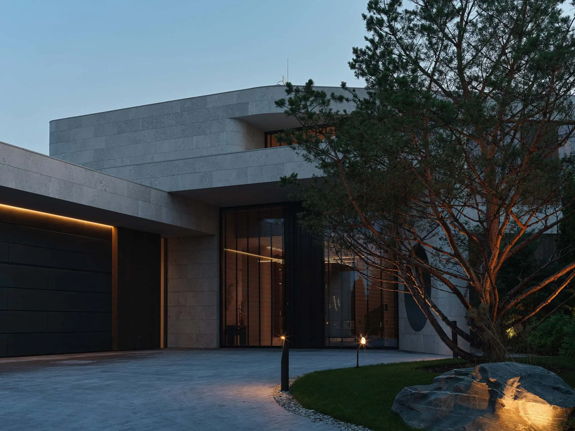 现代石制别墅，戏剧性夜景与树木。