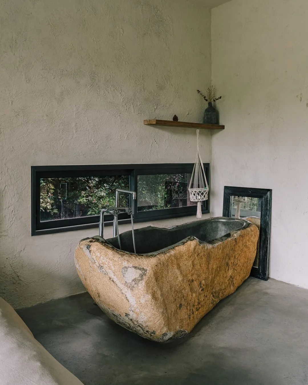 现代内饰中自由放置的天然石材浴缸。