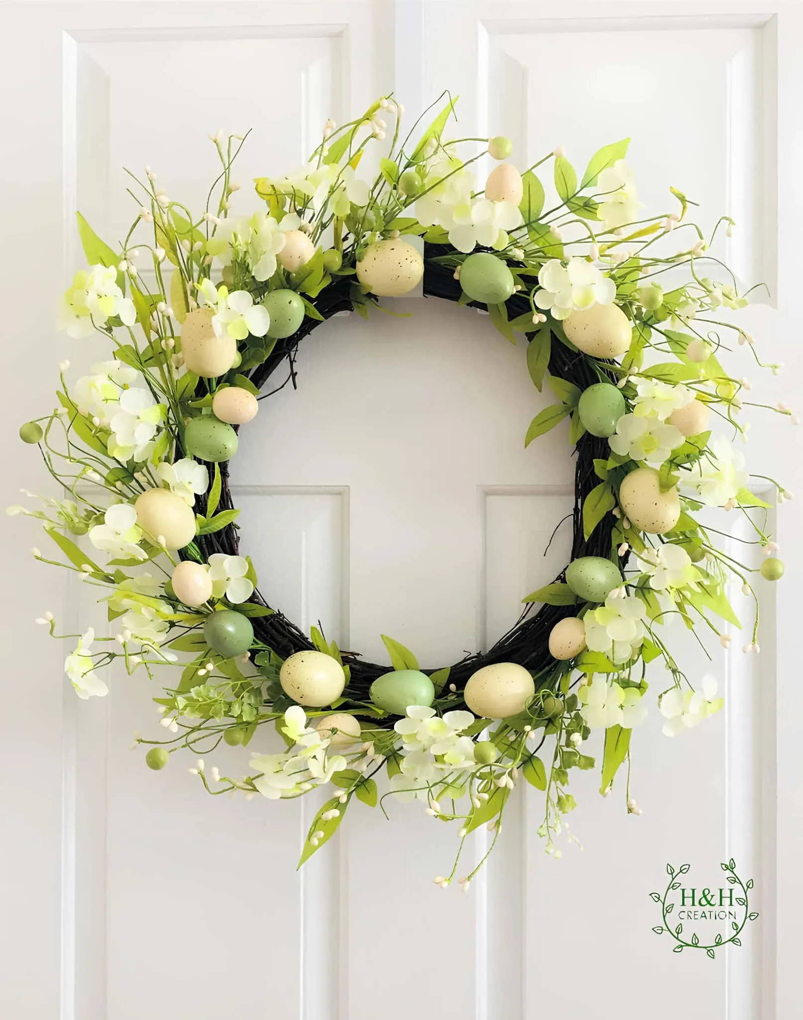 优雅的复活节门饰，配有绿色和奶油色调、鸡蛋和花朵