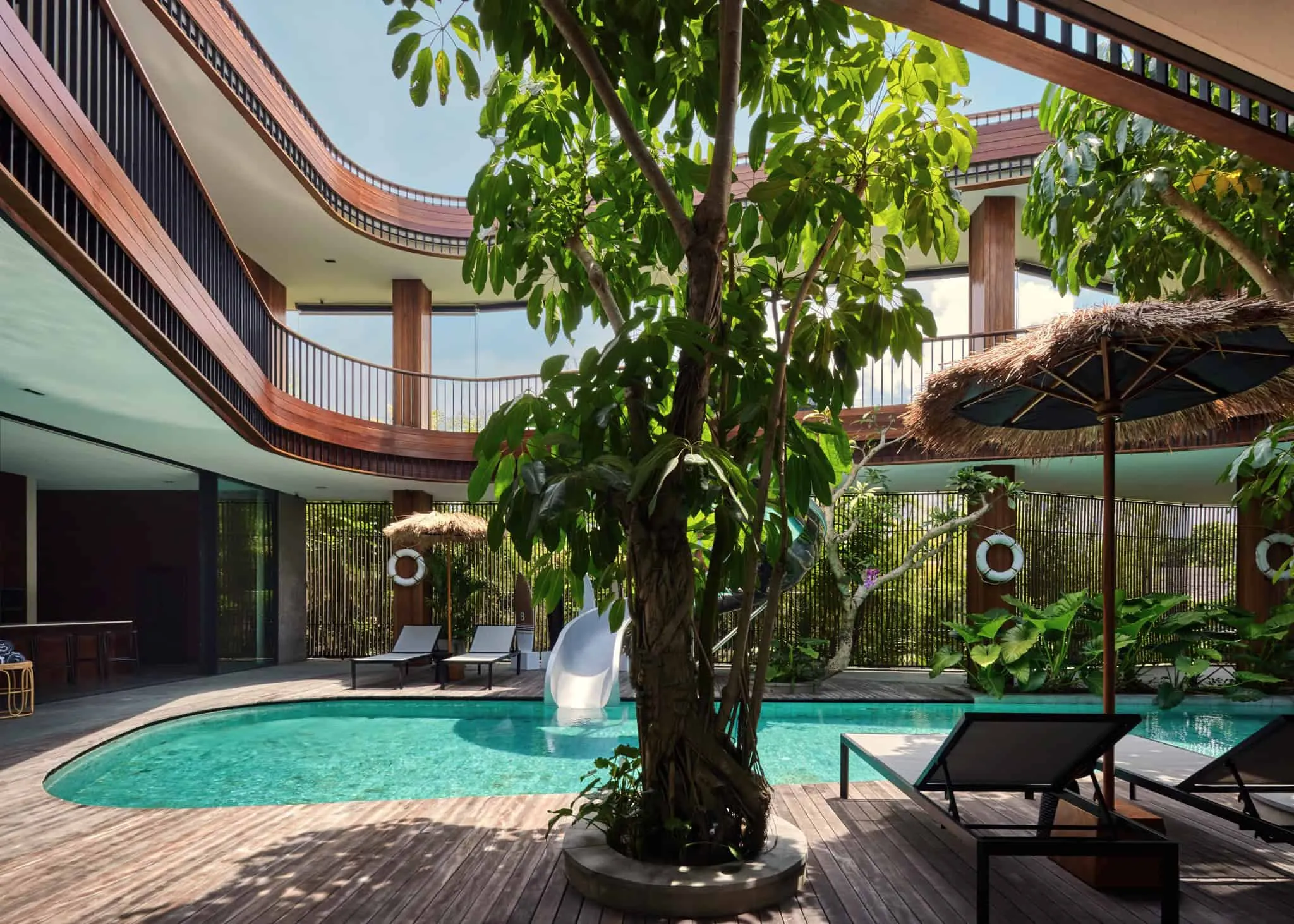 巴厘岛中央泳池与弯曲小径的绿色露台。