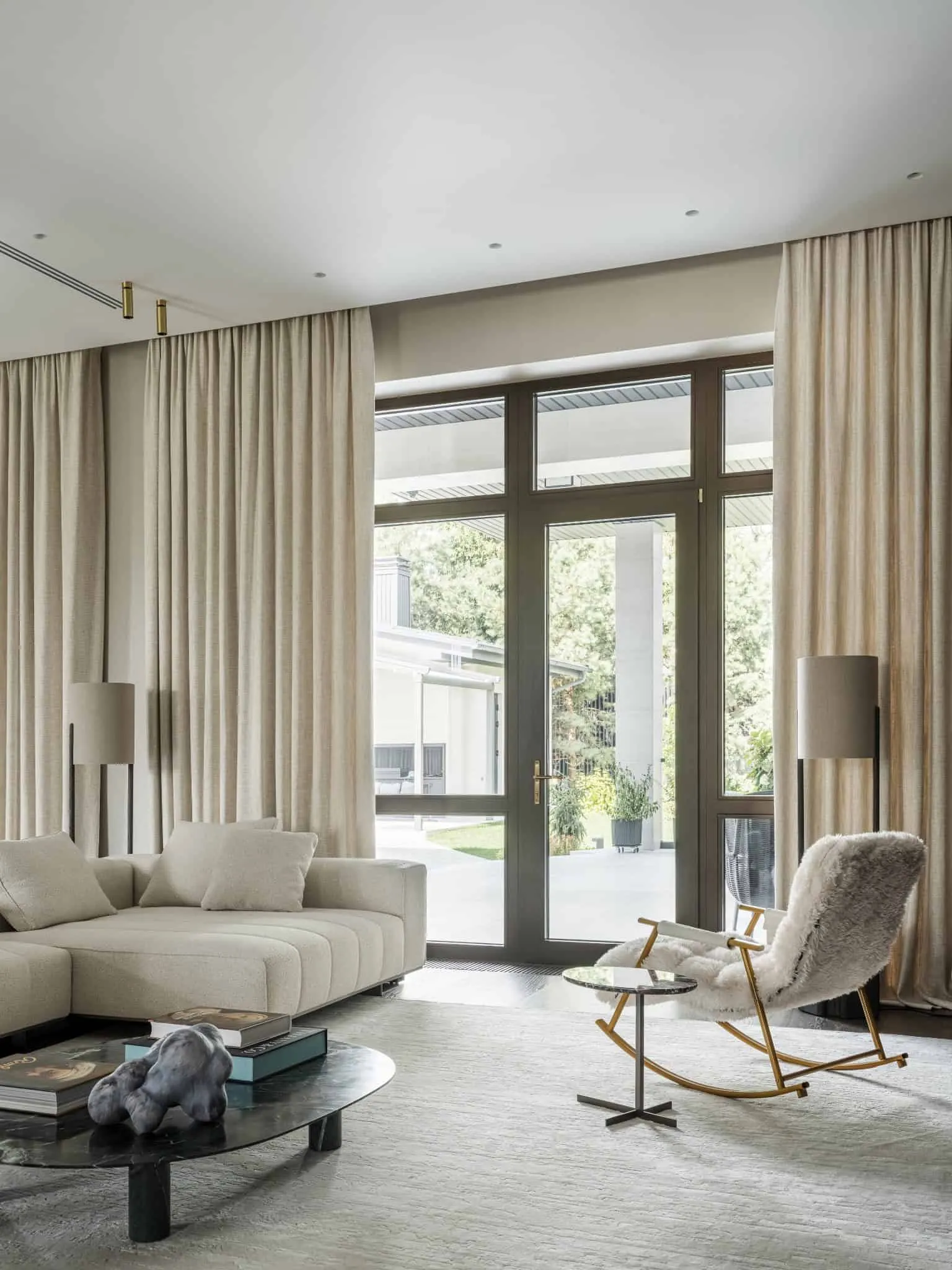 Просторовий інтер'єр з великими скляними дверима, що ведуть у двір.