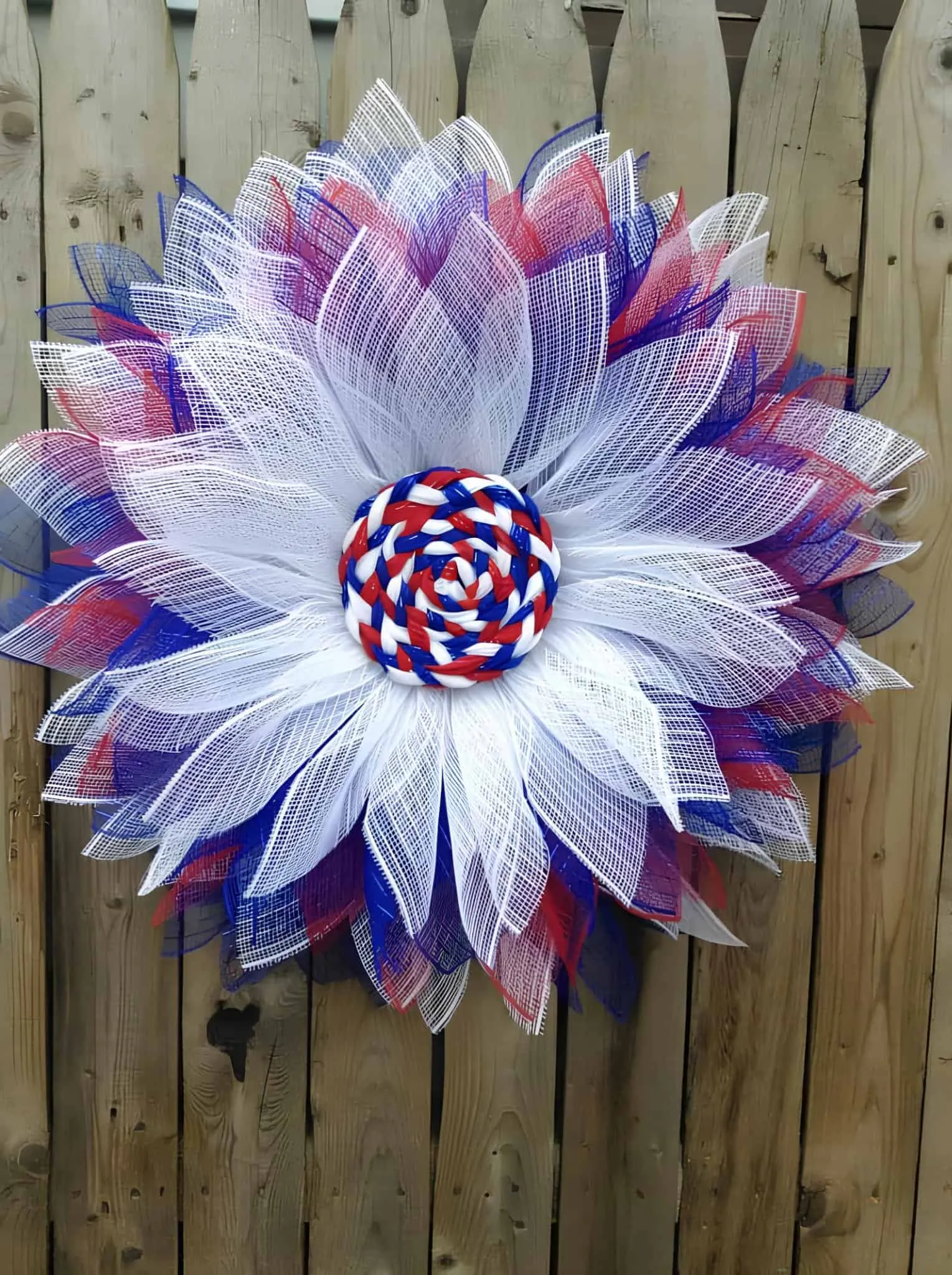 大花朵花环，配有红、白、蓝网格花瓣和编织中心