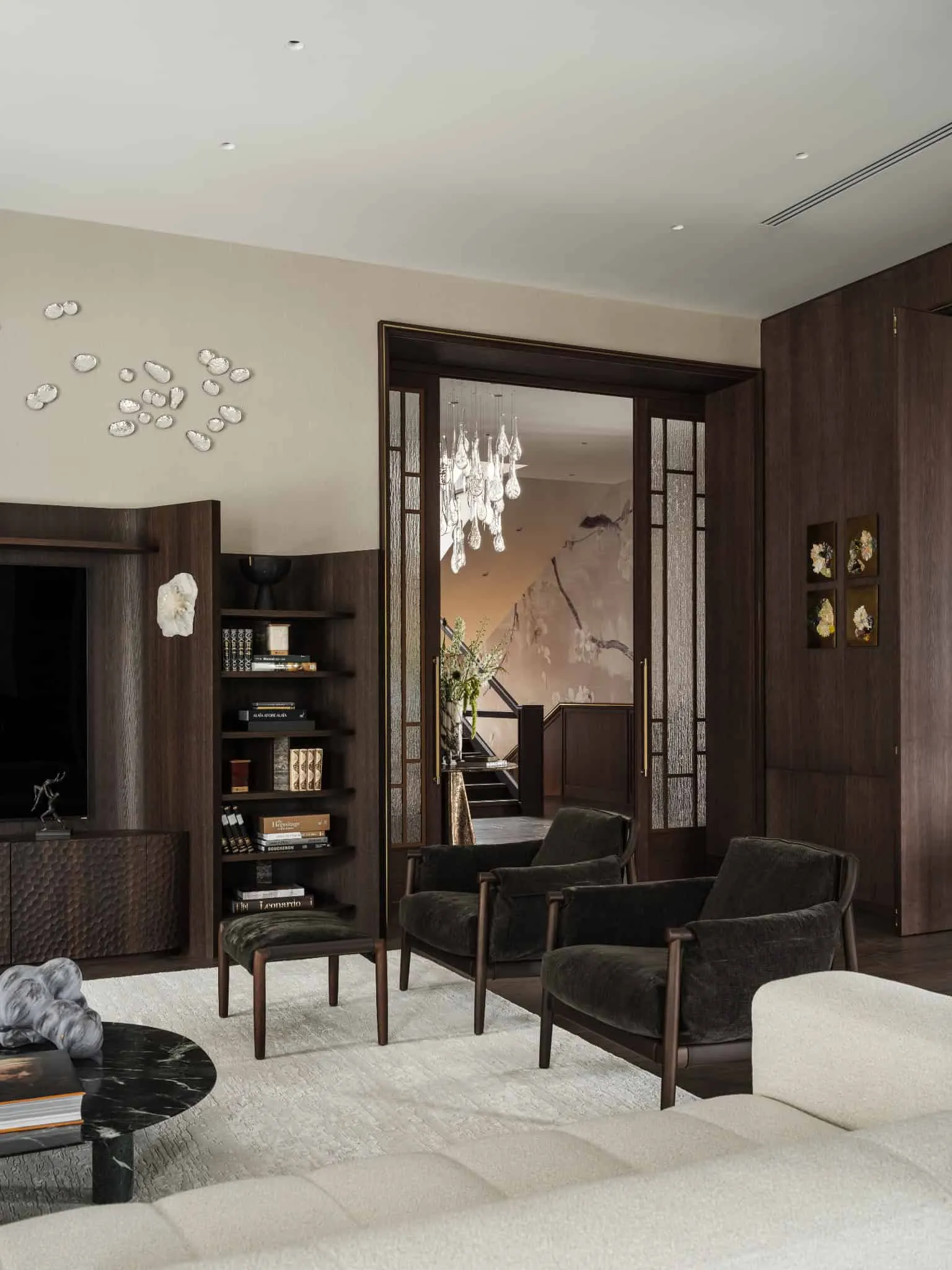 Сучасний простір гостинної, розглянутий через відкриті ковзні двері з коридору.