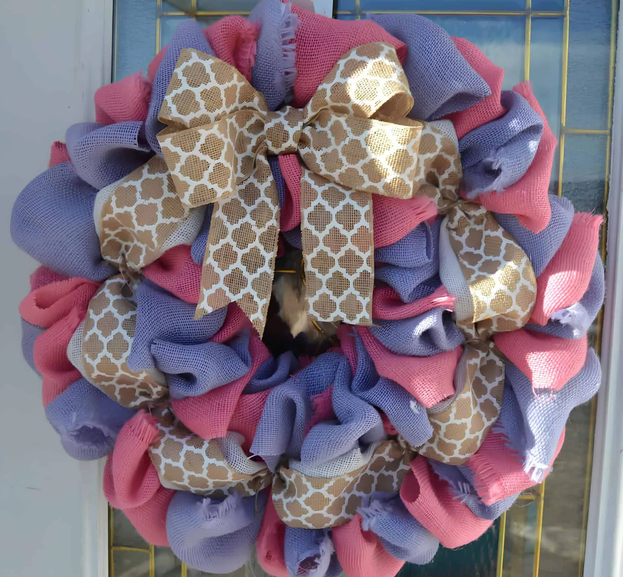 彩色复活节门饰，配有粉彩粉色和紫色粗麻丝带及图案丝带