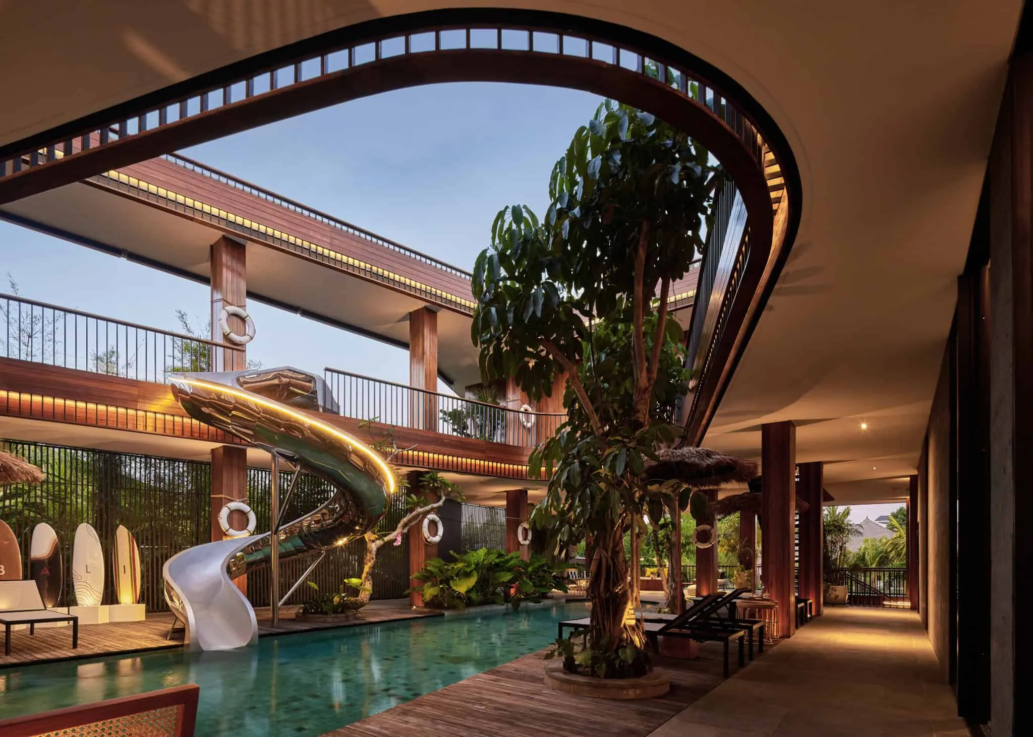 别墅泳池、热带树木和柔和灯光的夜晚景色。