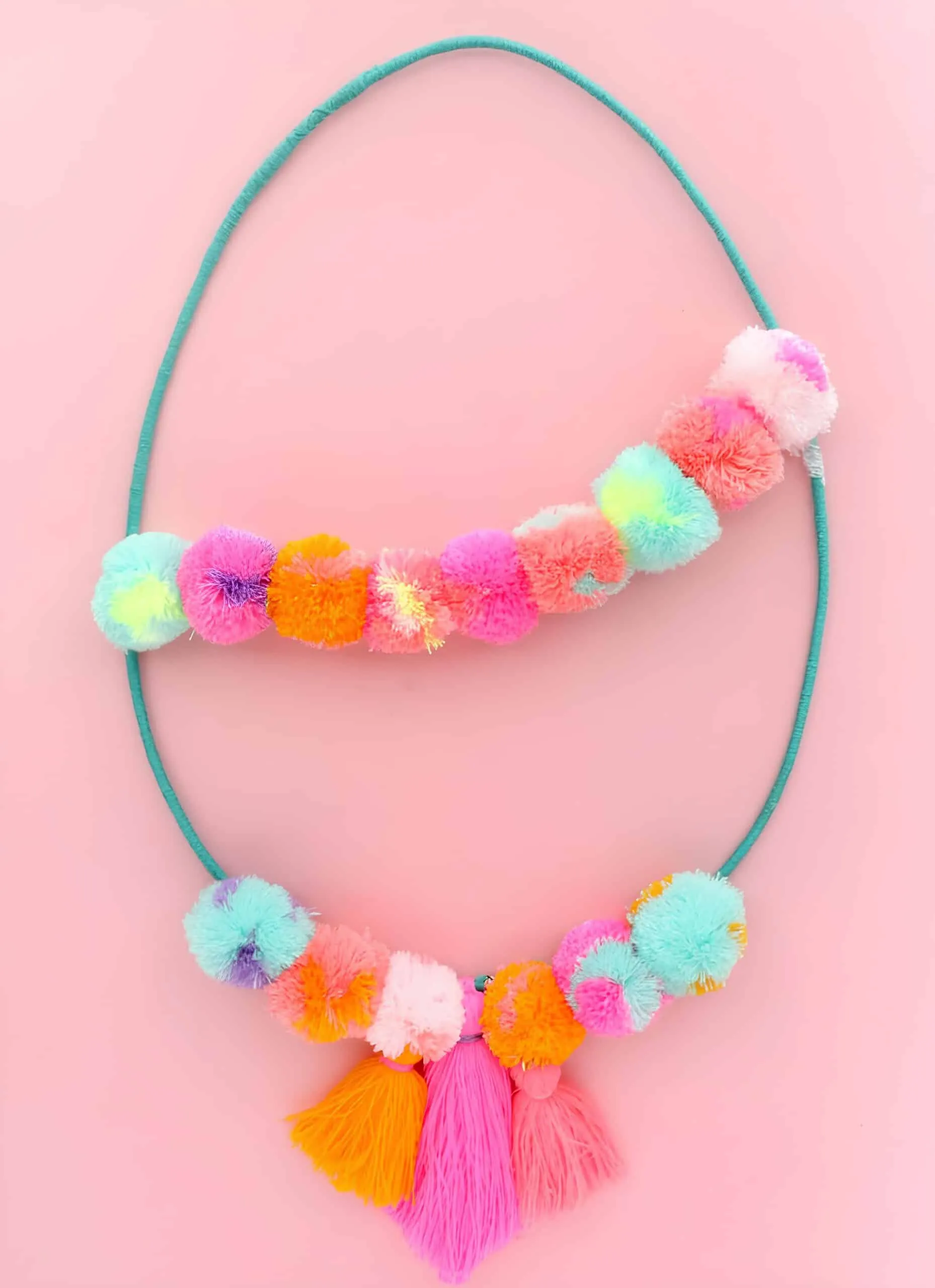 现代鸡蛋门饰，配有鲜艳的兔耳朵和手柄丝带，在粉红背景上。