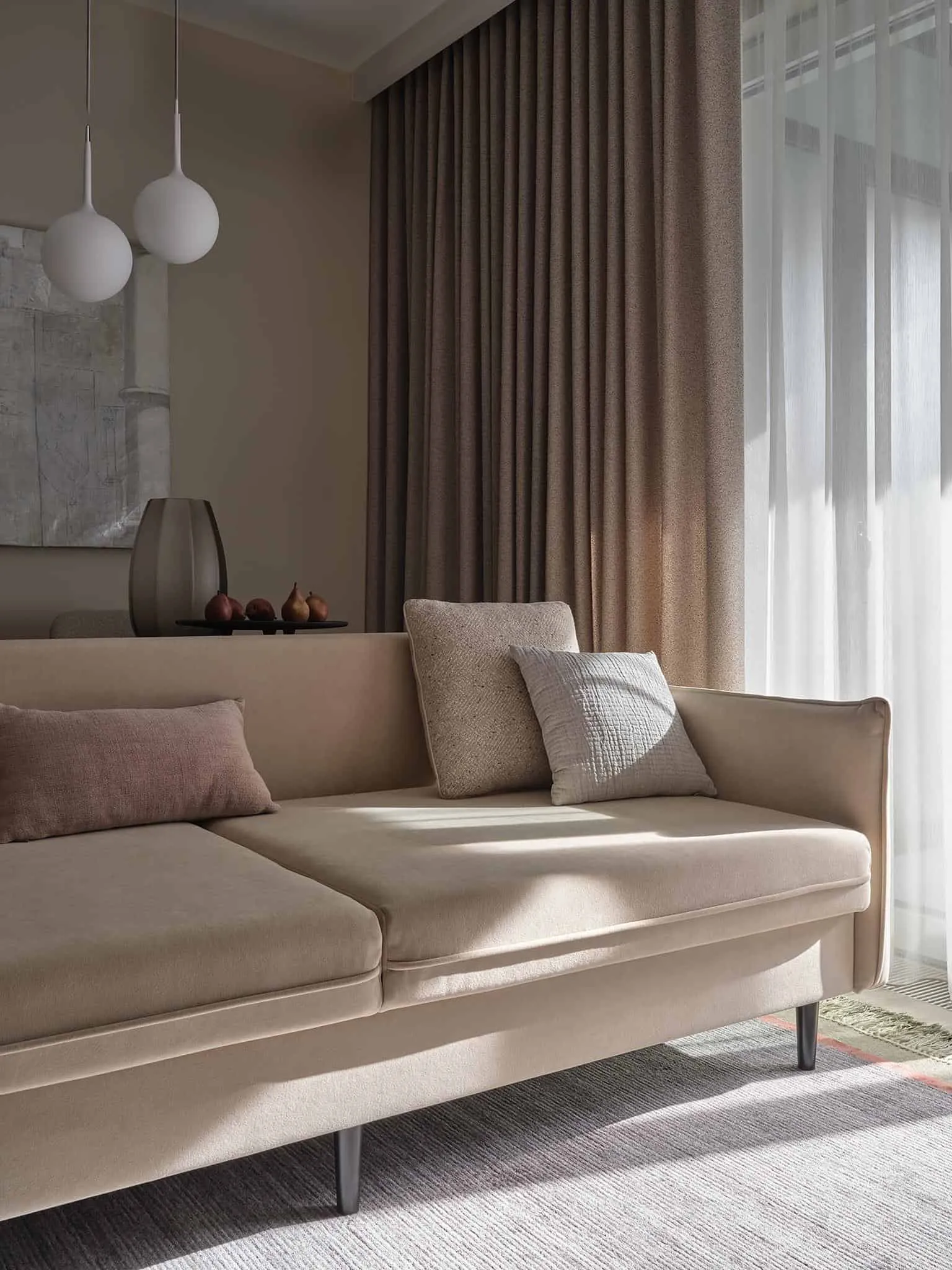 米色沙发与从地板到天花板的窗帘特写，营造出中性内饰氛围。