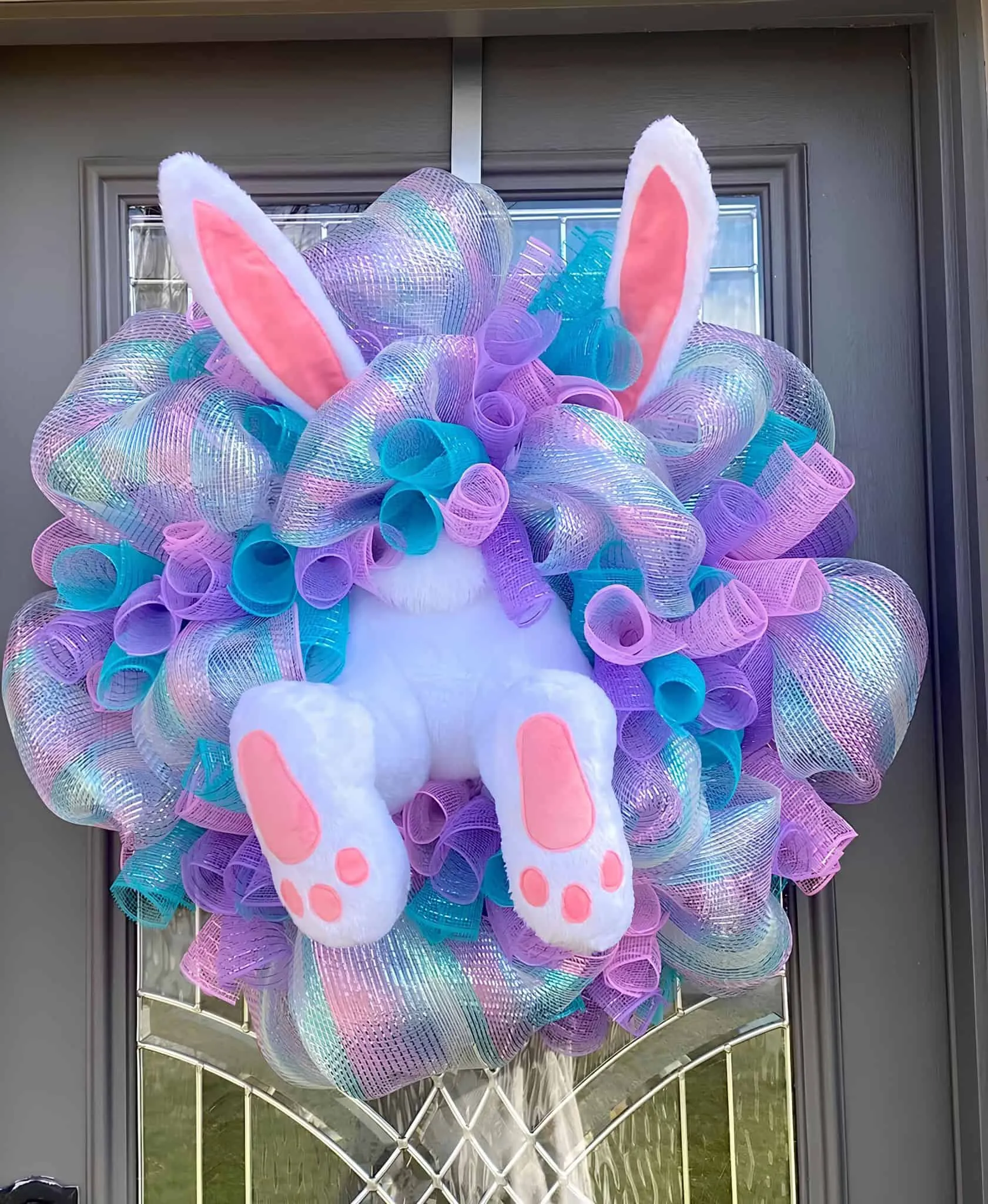 复活节门饰，配有毛绒兔子耳朵和粉彩丝带