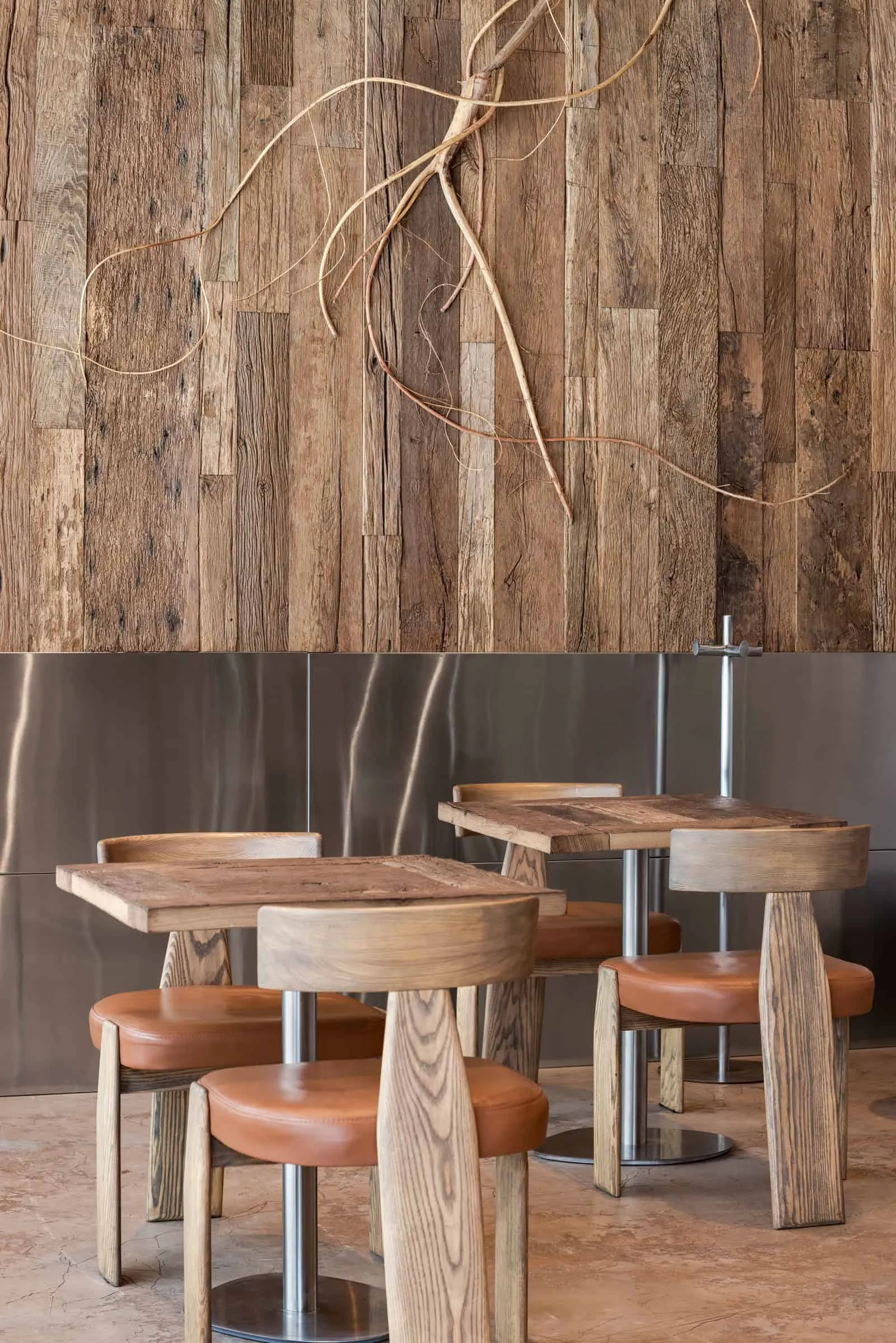 温暖咖啡馆内饰中的方形木质桌子和圆形皮质座椅