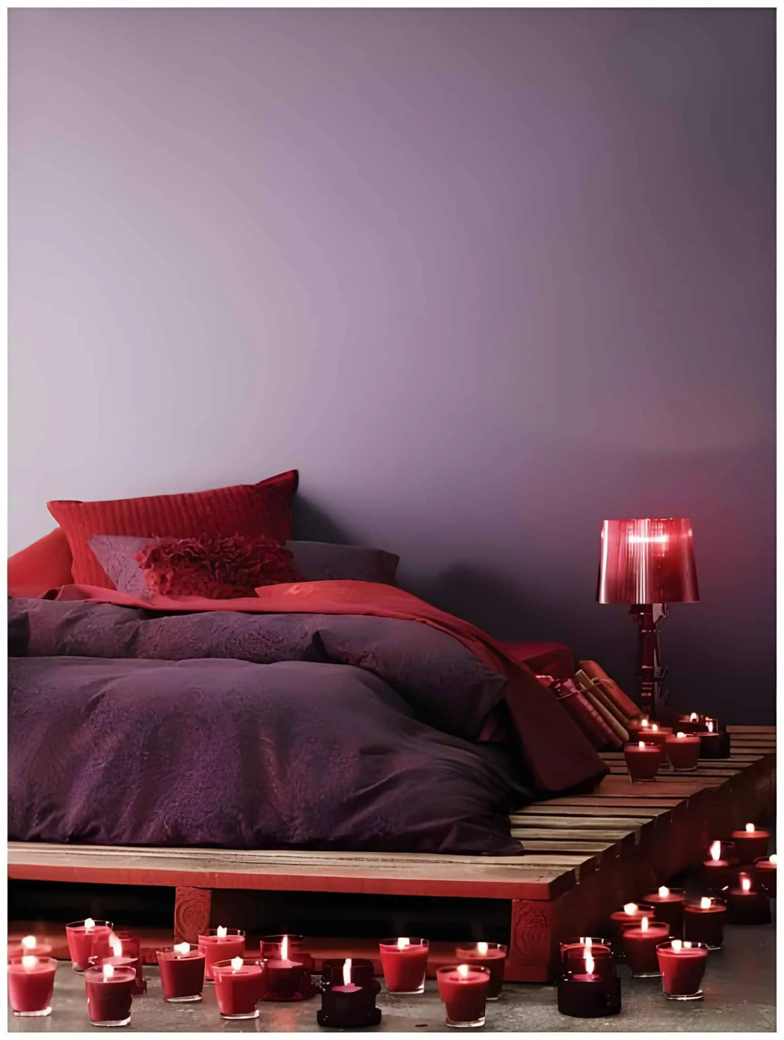 周围有发光红色蜡烛的低木质托盘床。