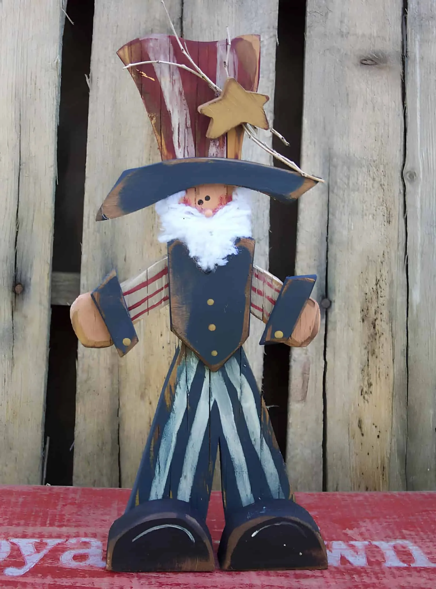 涂成红白蓝颜色的木制山姆大叔雕像，配有复古细节用于4日节装饰
