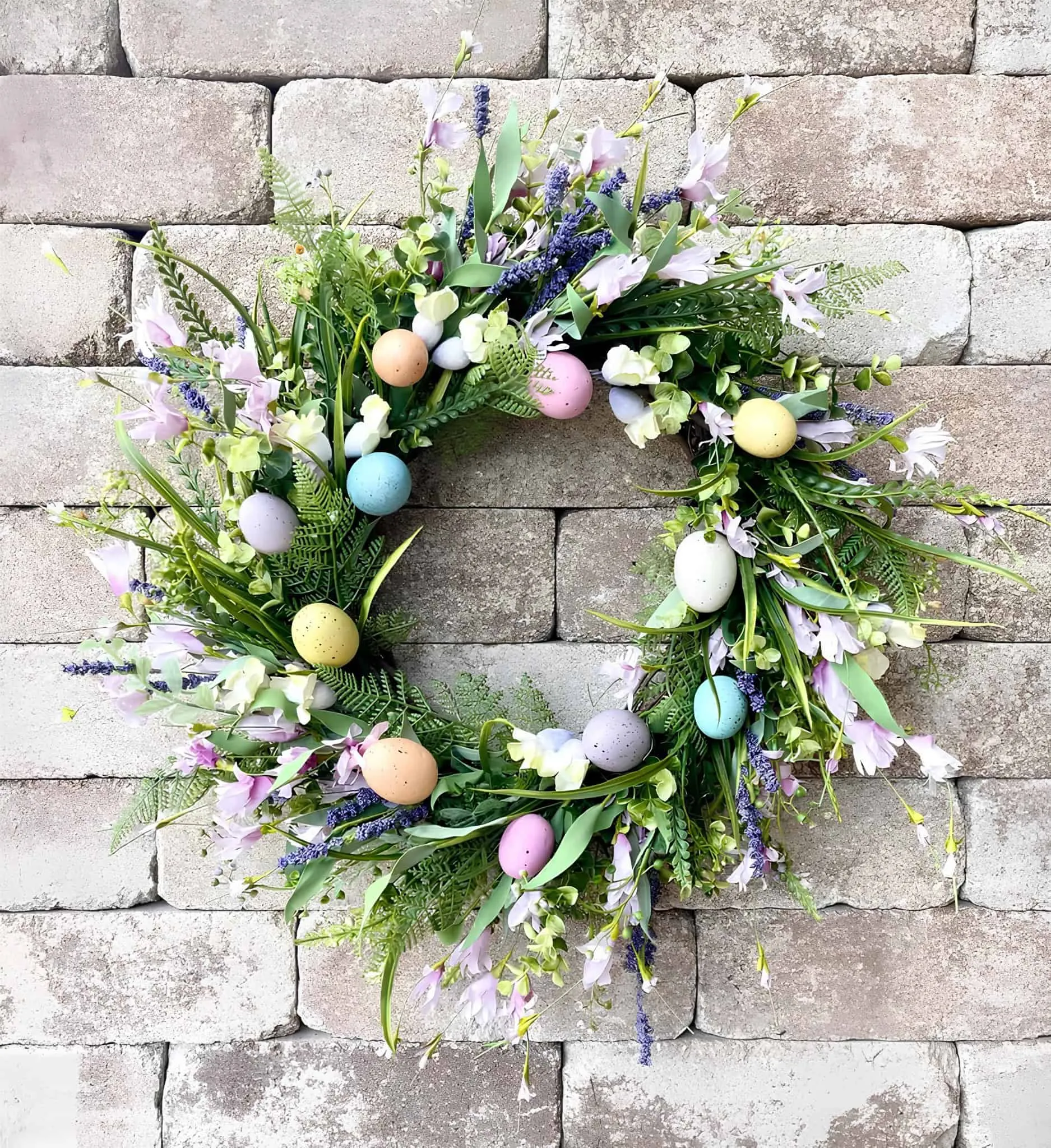 花朵复活节门饰，配有粉彩鸡蛋和薰衣草