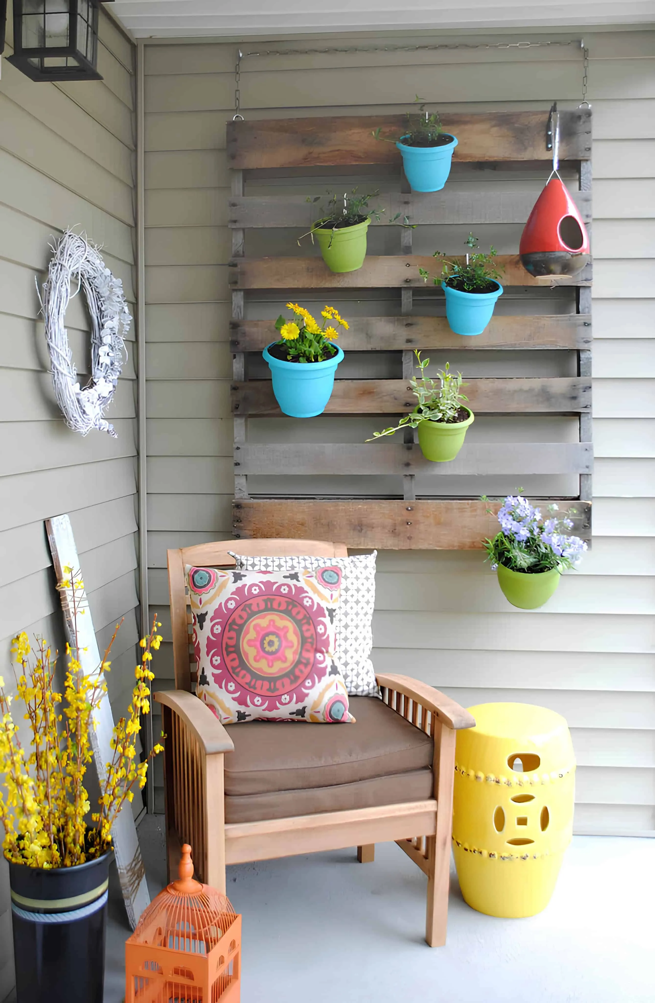 使用回收托盘制作的创意悬挂花园，配有露台墙上的花卉花盆