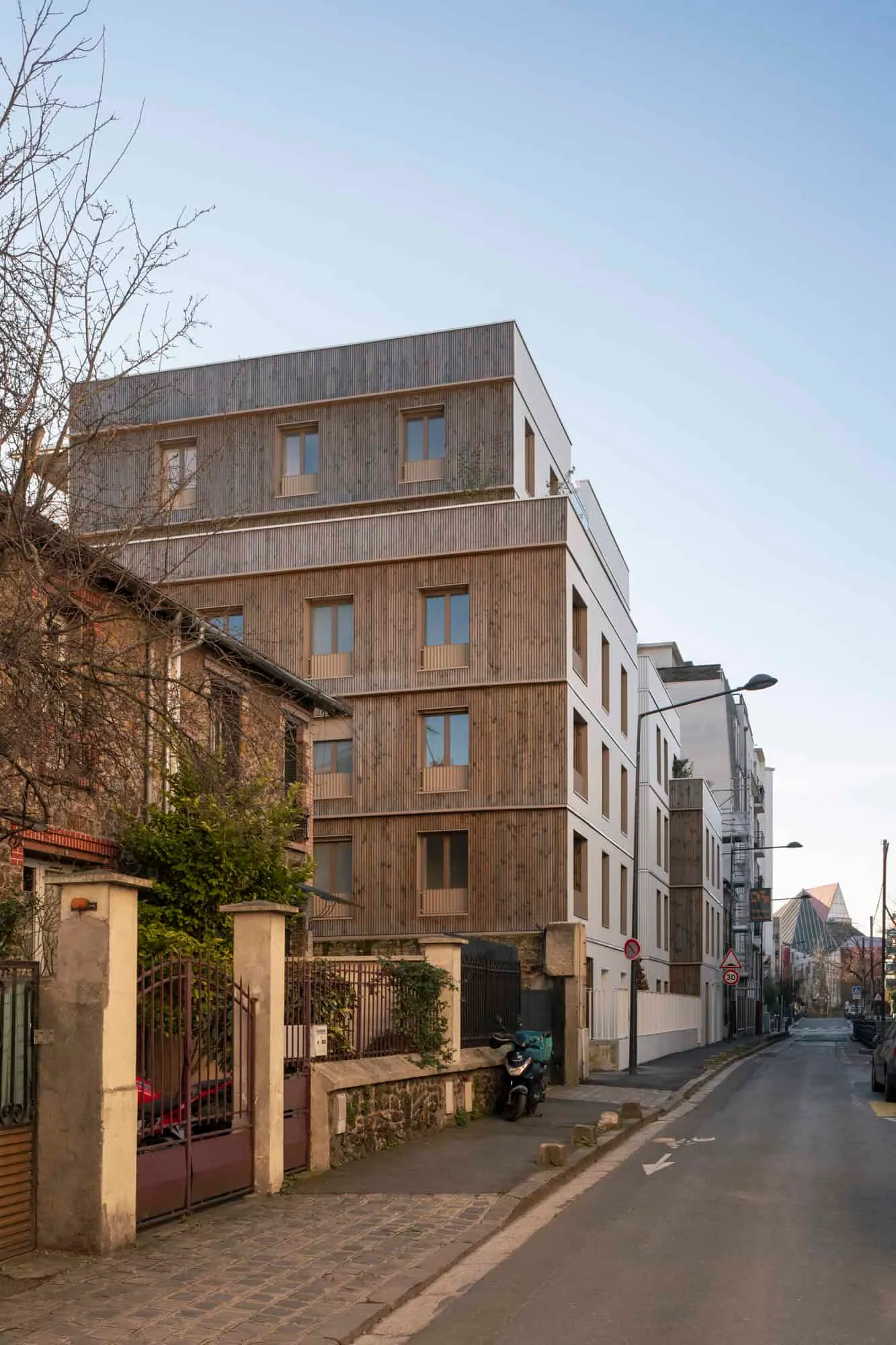 Corner view with vertical timber cladding on upper floors