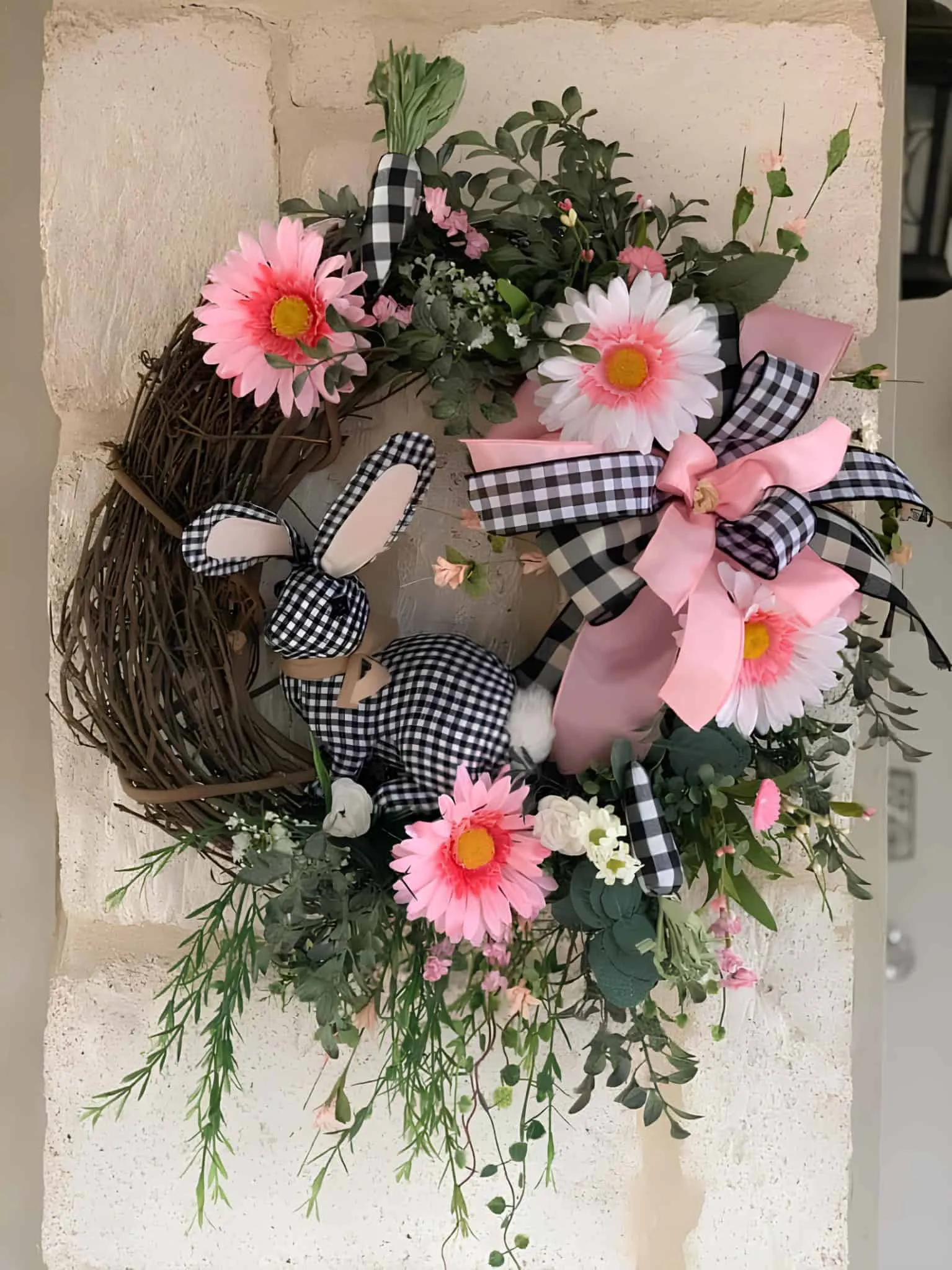 带有格子兔子和粉色春天花朵的复活节门饰