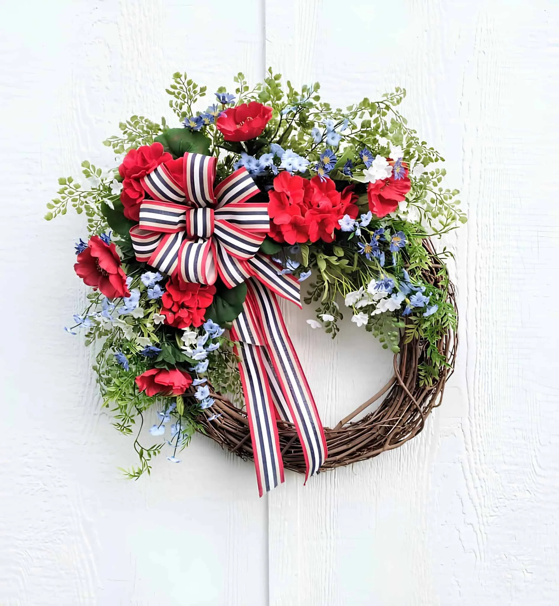 葡萄藤花环，装饰红、白、蓝花朵和条纹丝带