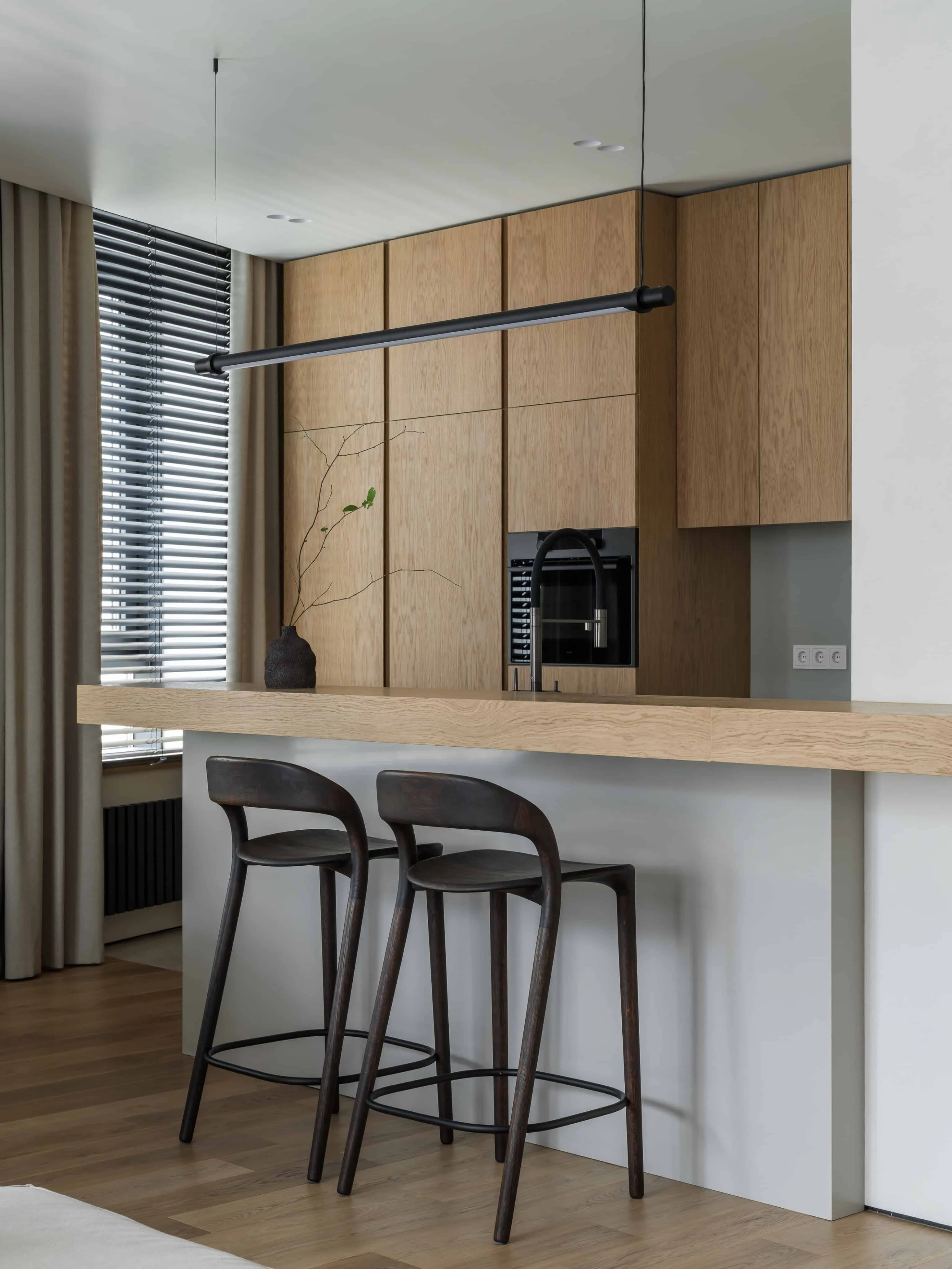 餐桌旁配有现代吊灯和温馨布艺家具，靠近窗户。