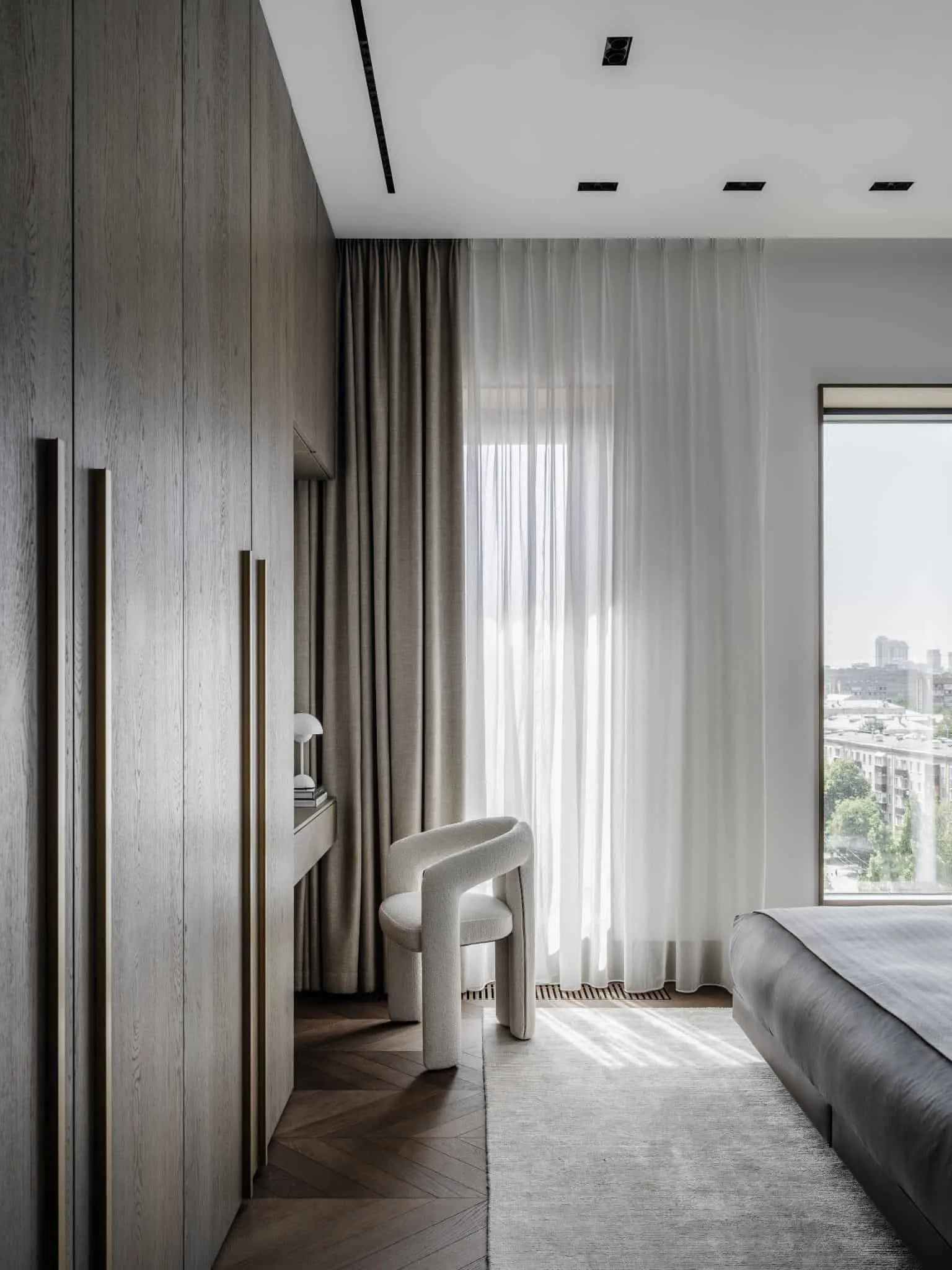 Wardrobe corner in bedroom with white chair.
