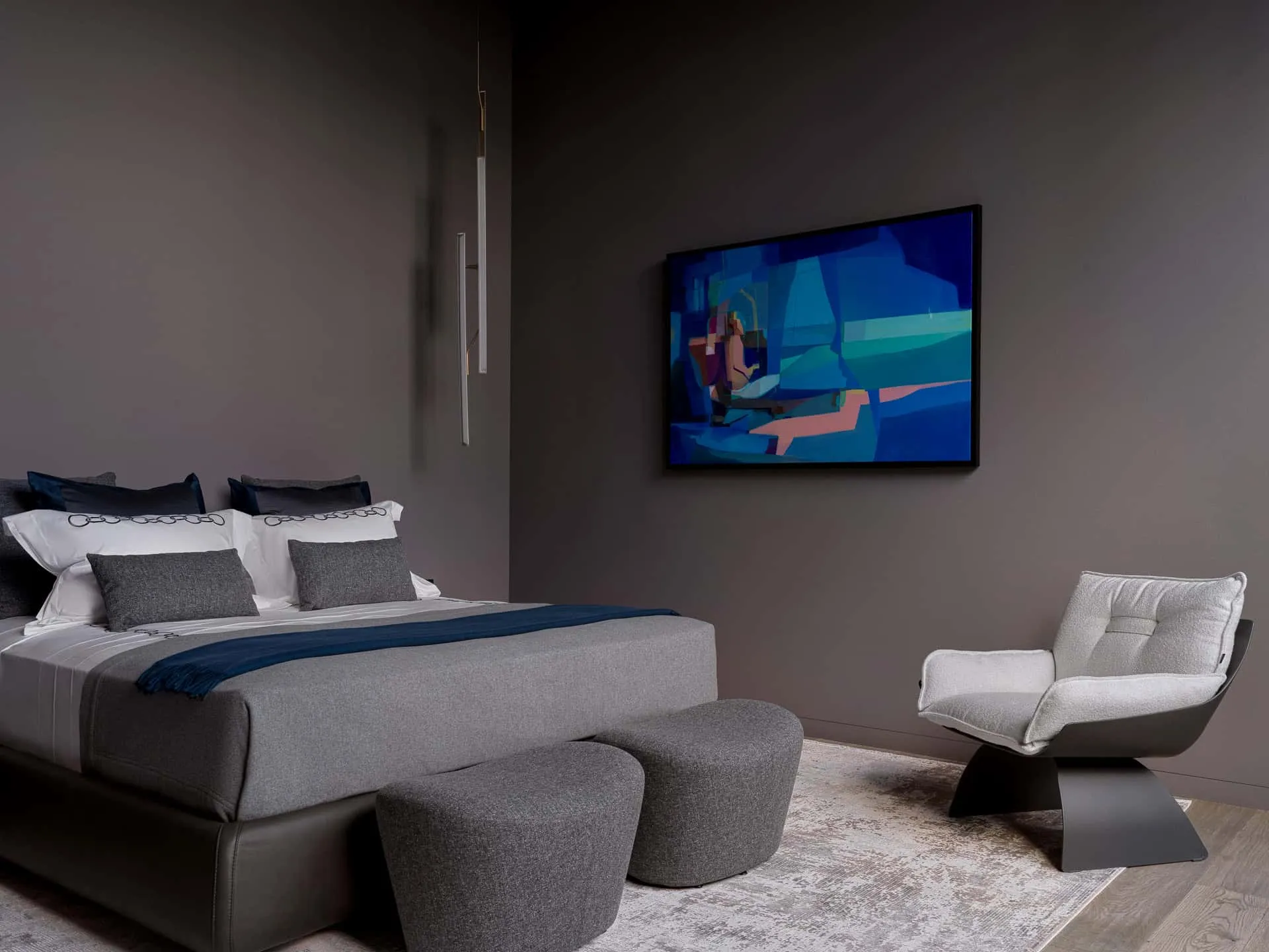 极简卧室，以单色调为主并配有一幅鲜艳的蓝色抽象画。