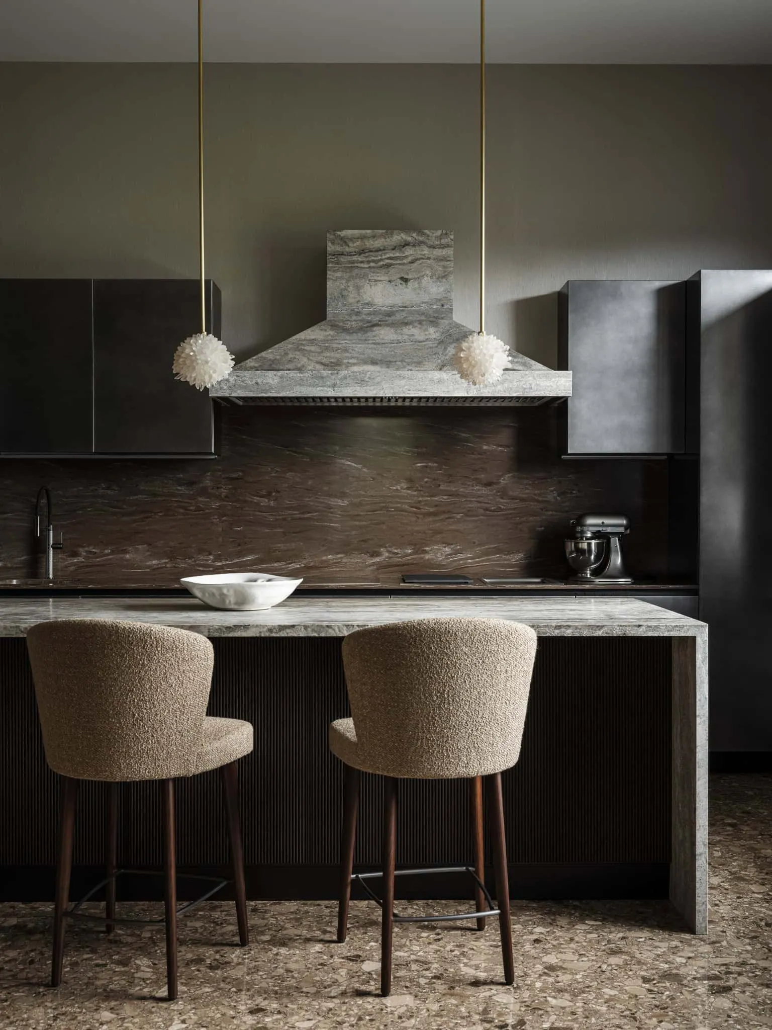 Крупний план барних стільців з м'яким тканням біля мраморної стійки.