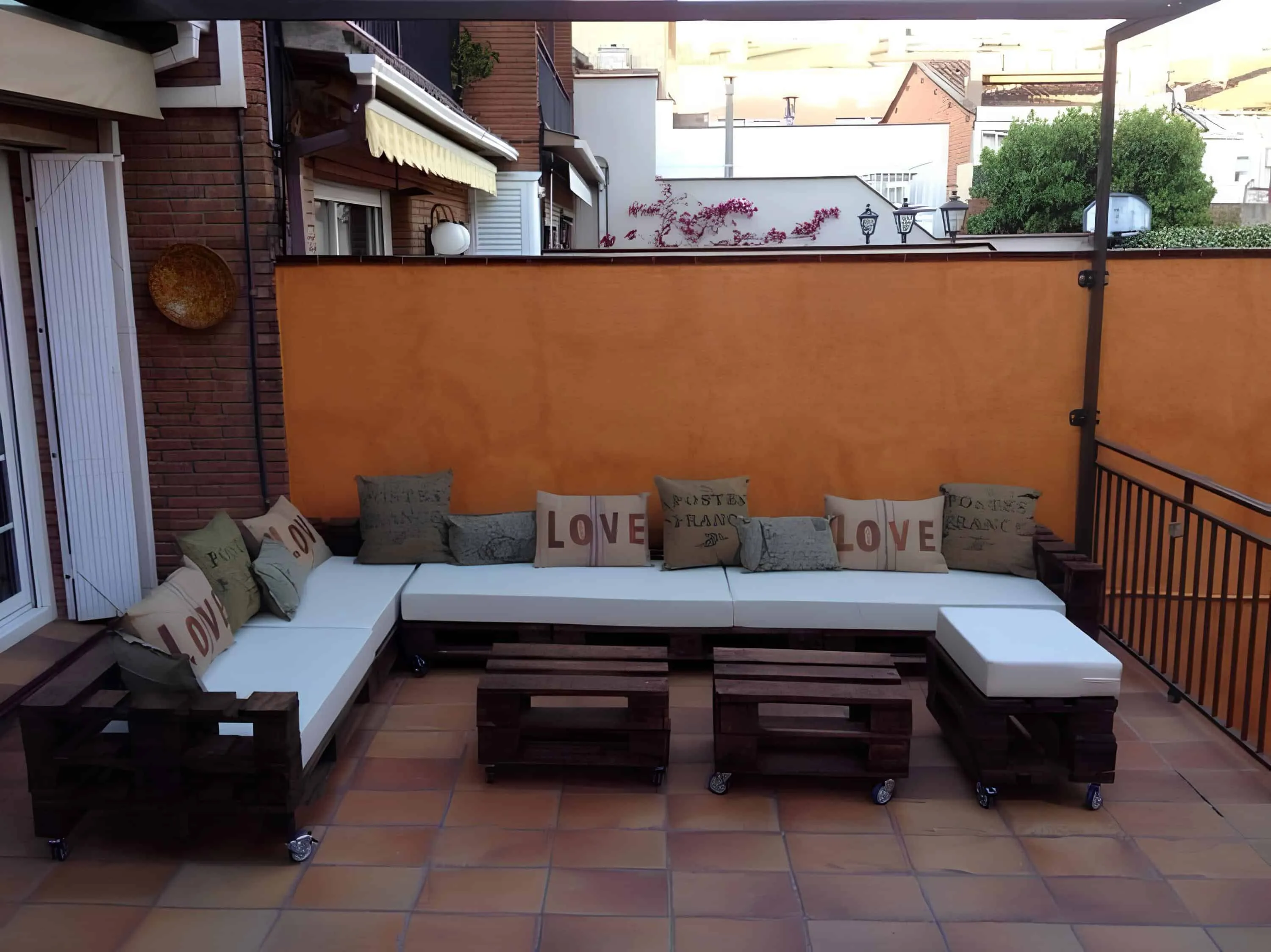 露台上的托盘L形沙发，配有白色和LOVE靠垫