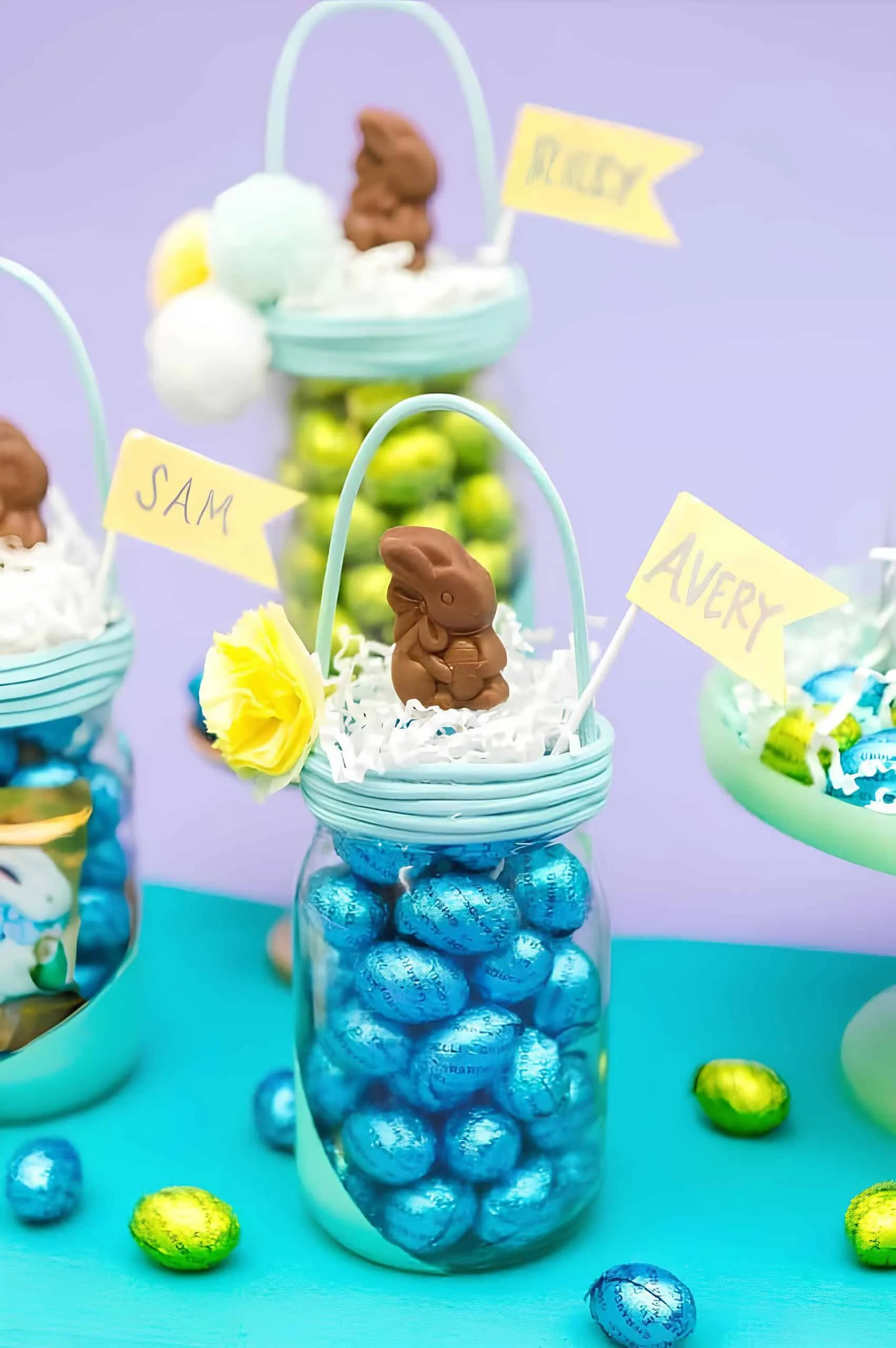 手工复活节 Mason 罐子，像篮子一样，装有鸡蛋糖果、巧克力兔子和姓名标签