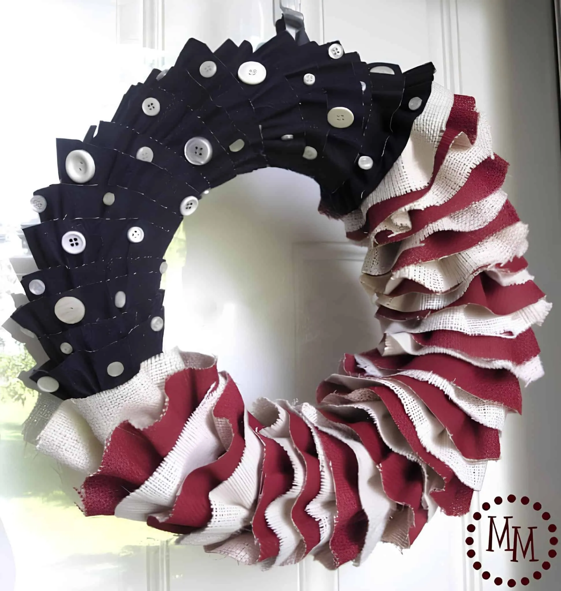 撕裂的红、白、蓝丝绸花环，配有白色纽扣星星