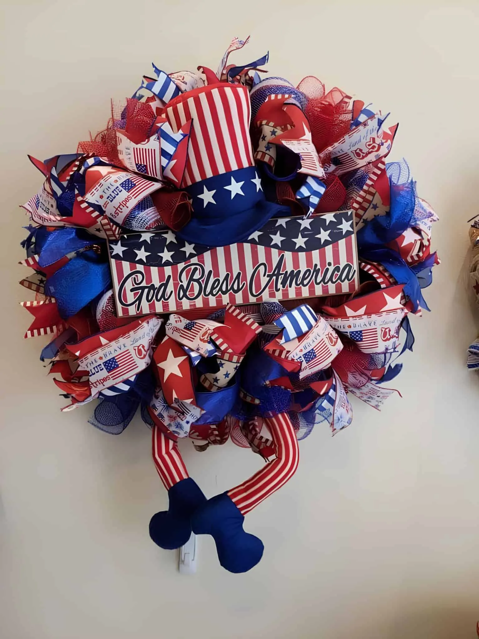 节日爱国花环，配有'上帝保佑美国'字样、帽子和红、白、蓝丝带