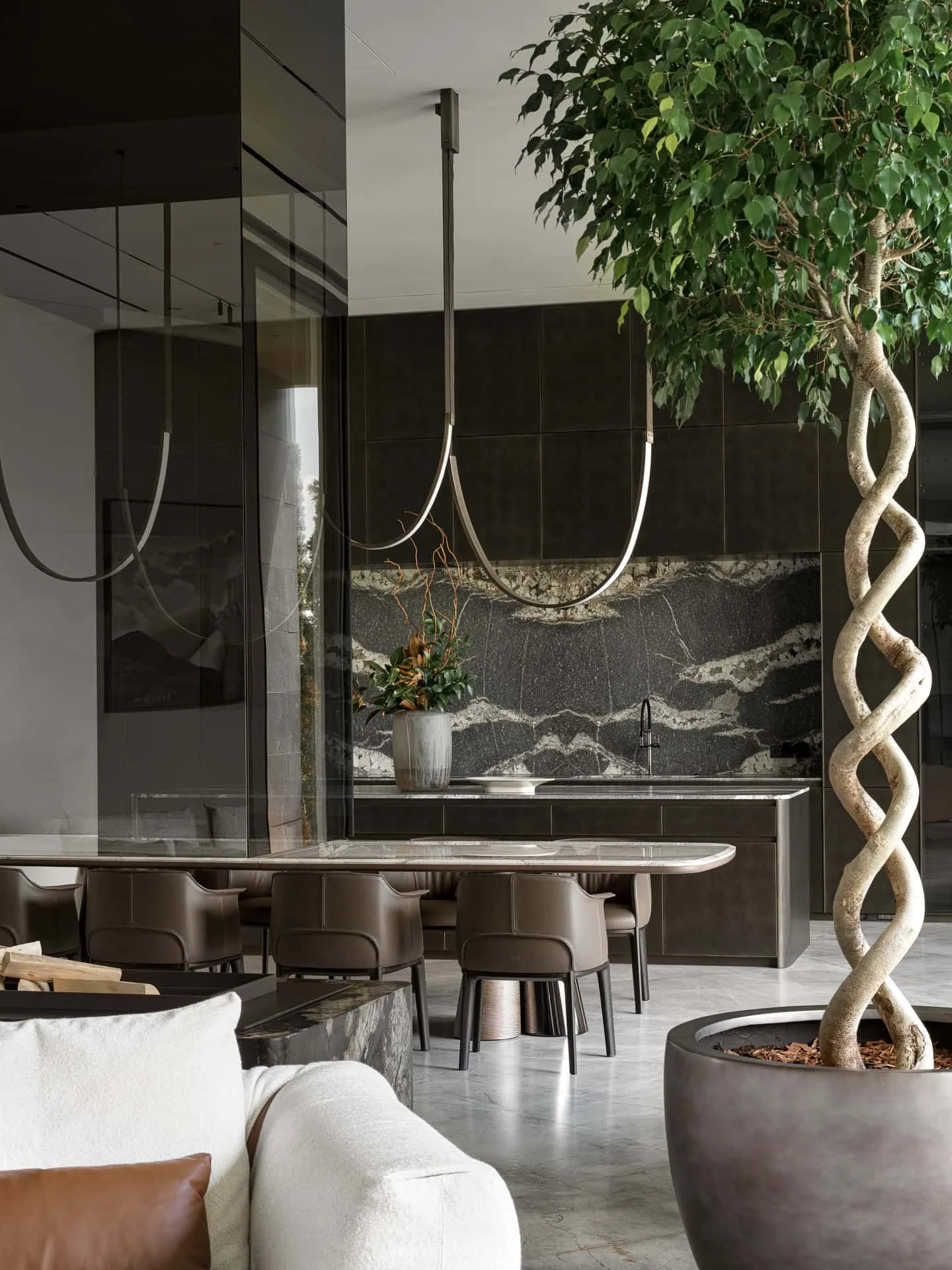设计感厨房，配有大理石后墙与餐区附近的木质花盆。