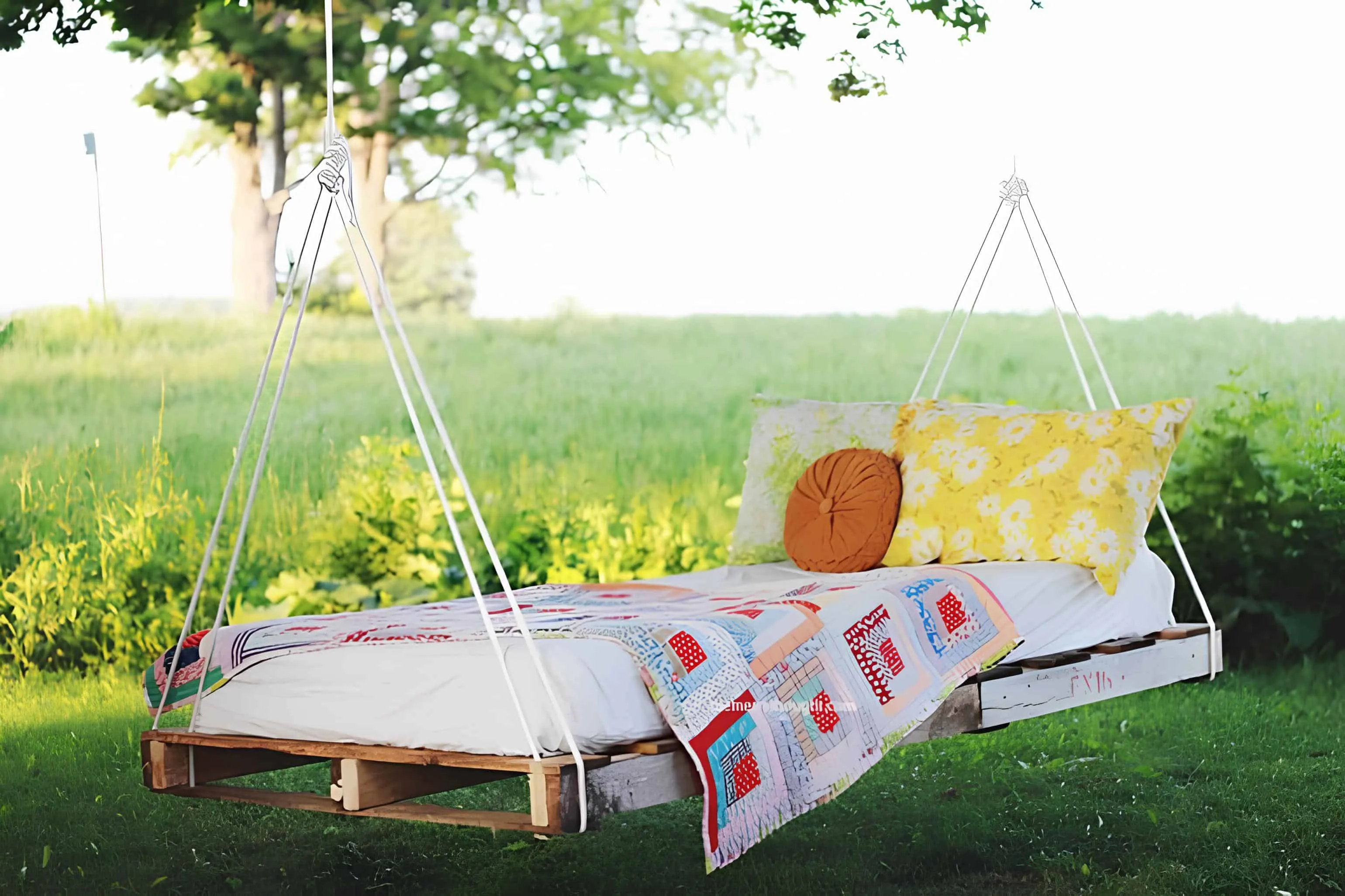 由木托盘和软垫制成的舒适悬挂午睡床，理想的阅读、放松或树下休息